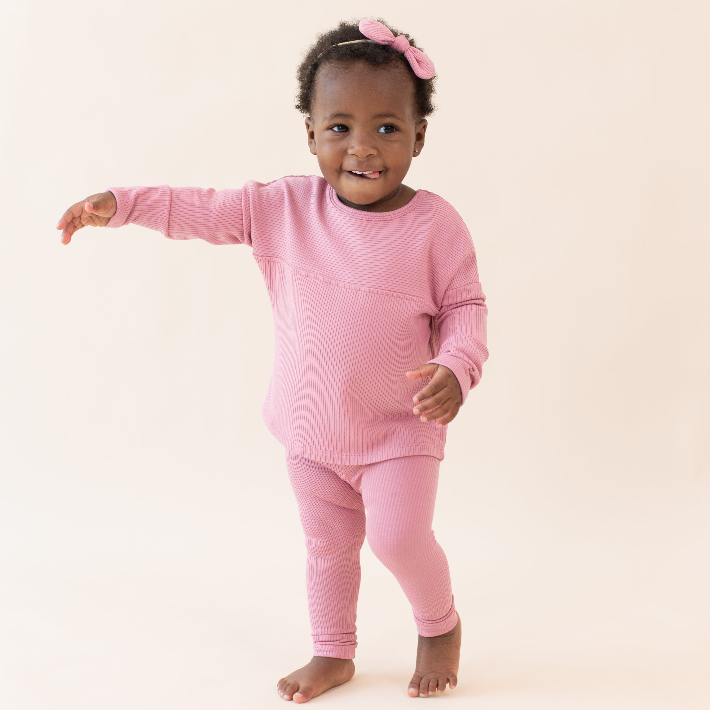 Toddler wearing Kyte Baby Top with Drop Shoulder and Curved Hem in Apple Blossom