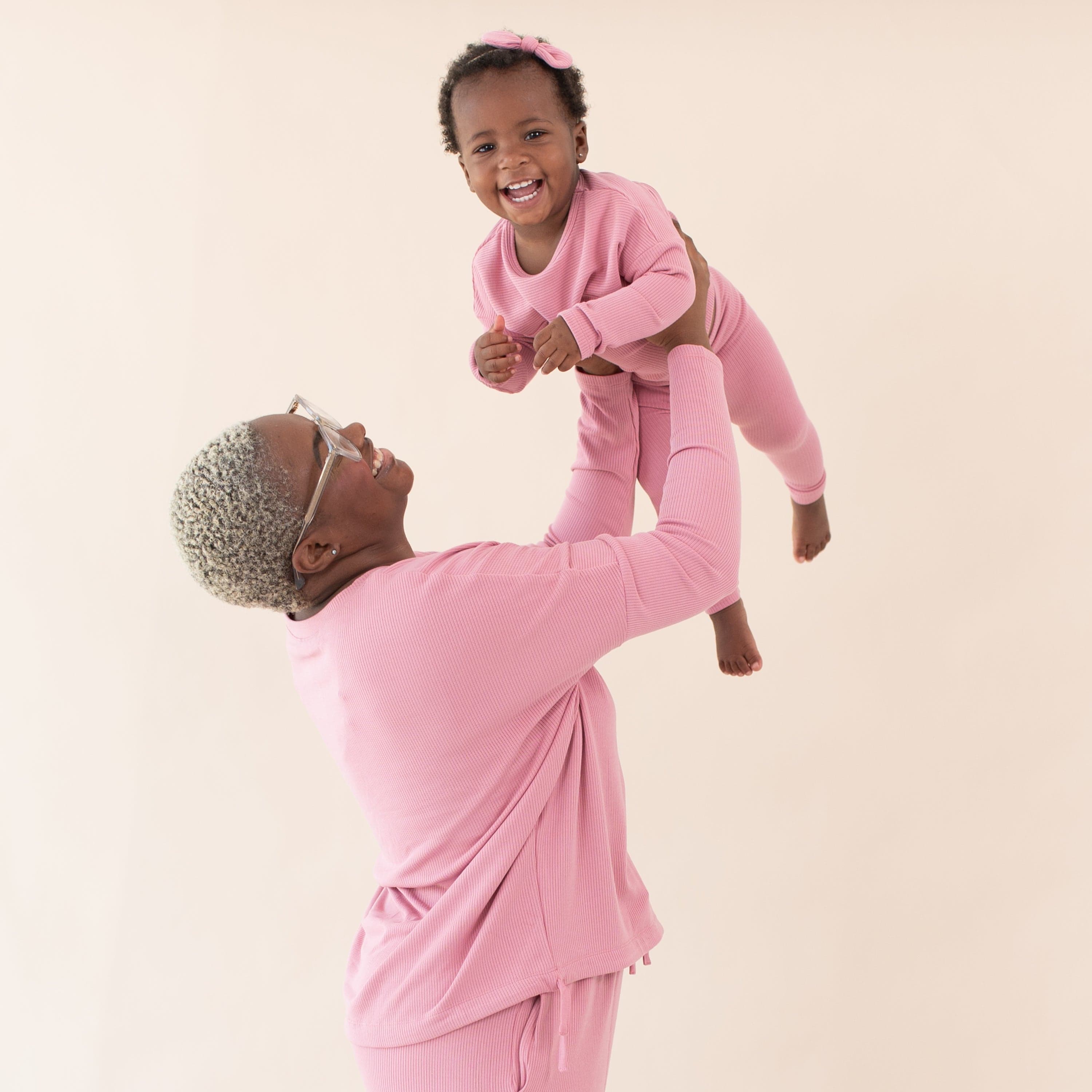 Mom holding Toddler wearing Kyte Baby Bamboo Ribbed Drop Shoulder Top in Apple Blossom