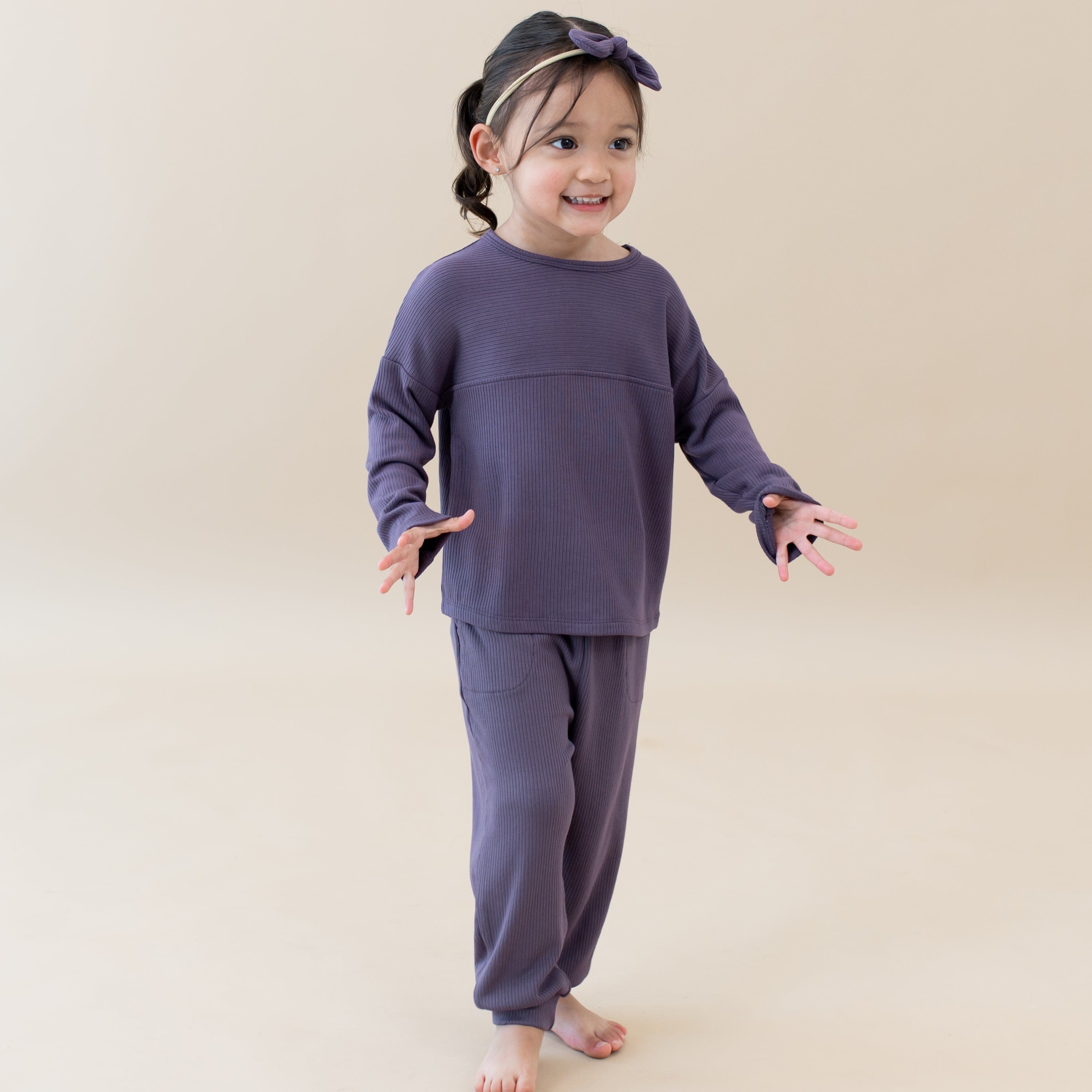 Toddler wearing Kyte Baby Top with Drop Shoulder and Curved Hem in Currant