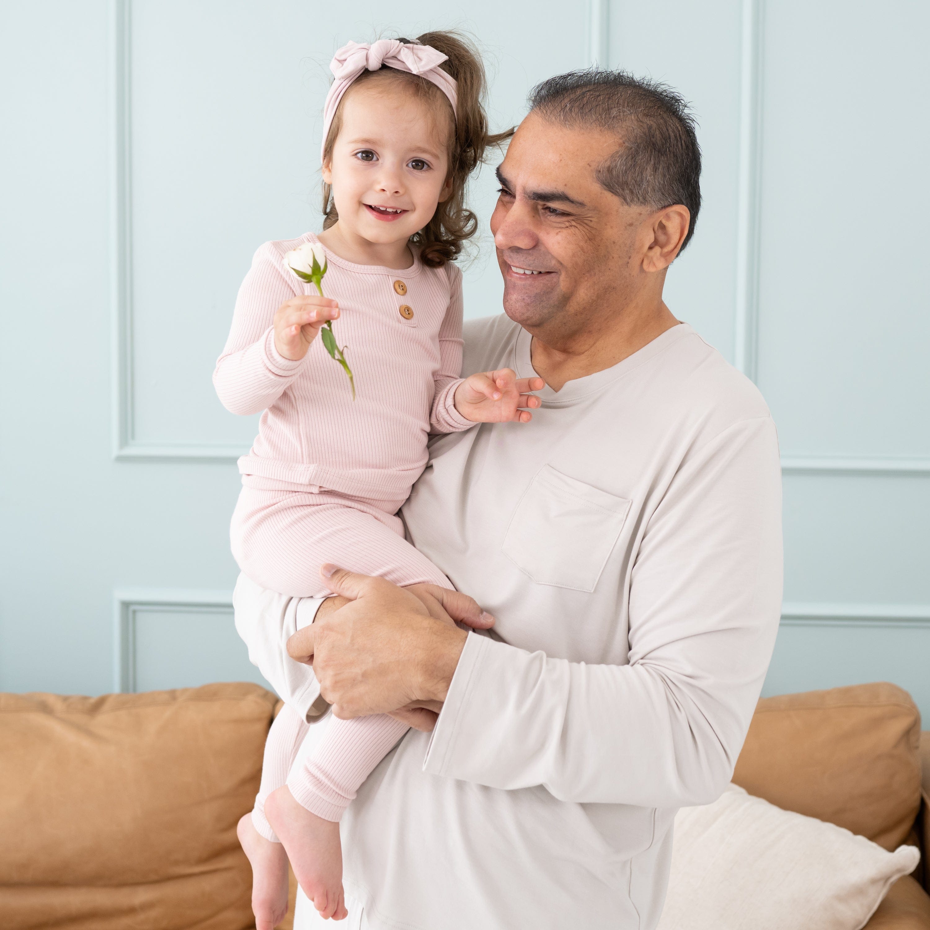Dad holding toddler wearing Kyte Baby Ribbed Henley Set with wooden buttons in Blush