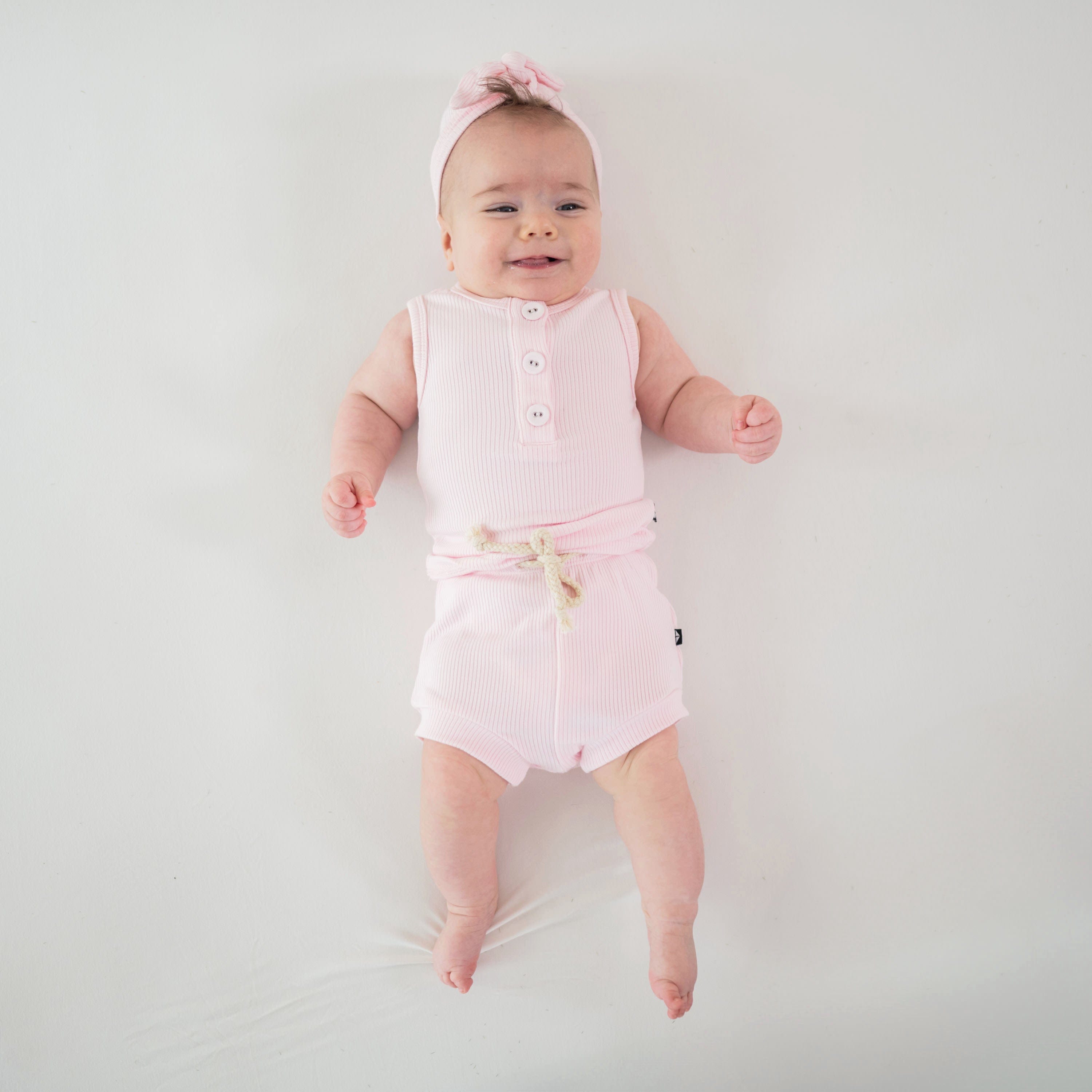 Infant wearing Kyte Baby Ribbed Henley Tank and Shorts Set in Sakura pink