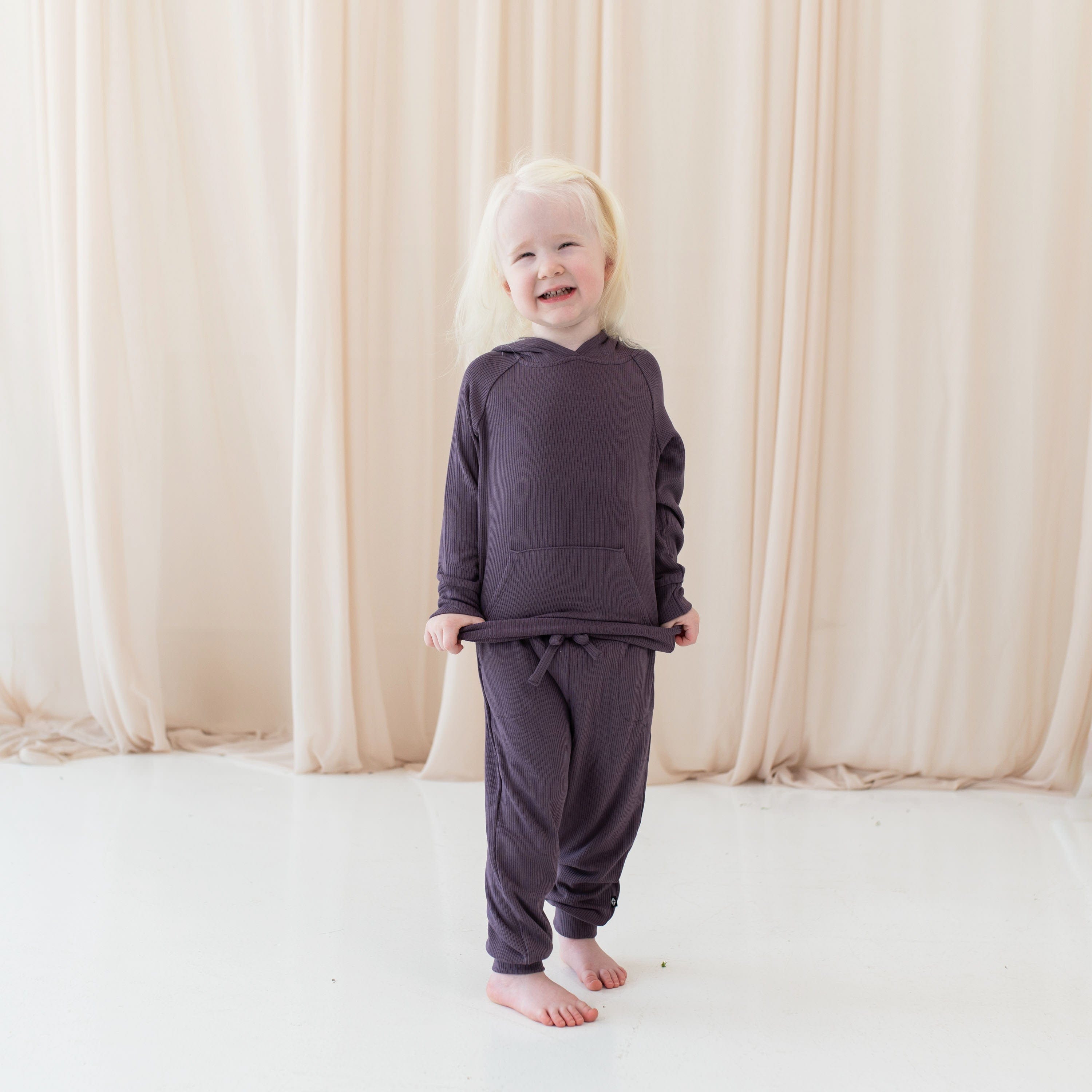 Girl wearing Kyte Baby Ribbed Jogger Hoodie and Pant in Currant