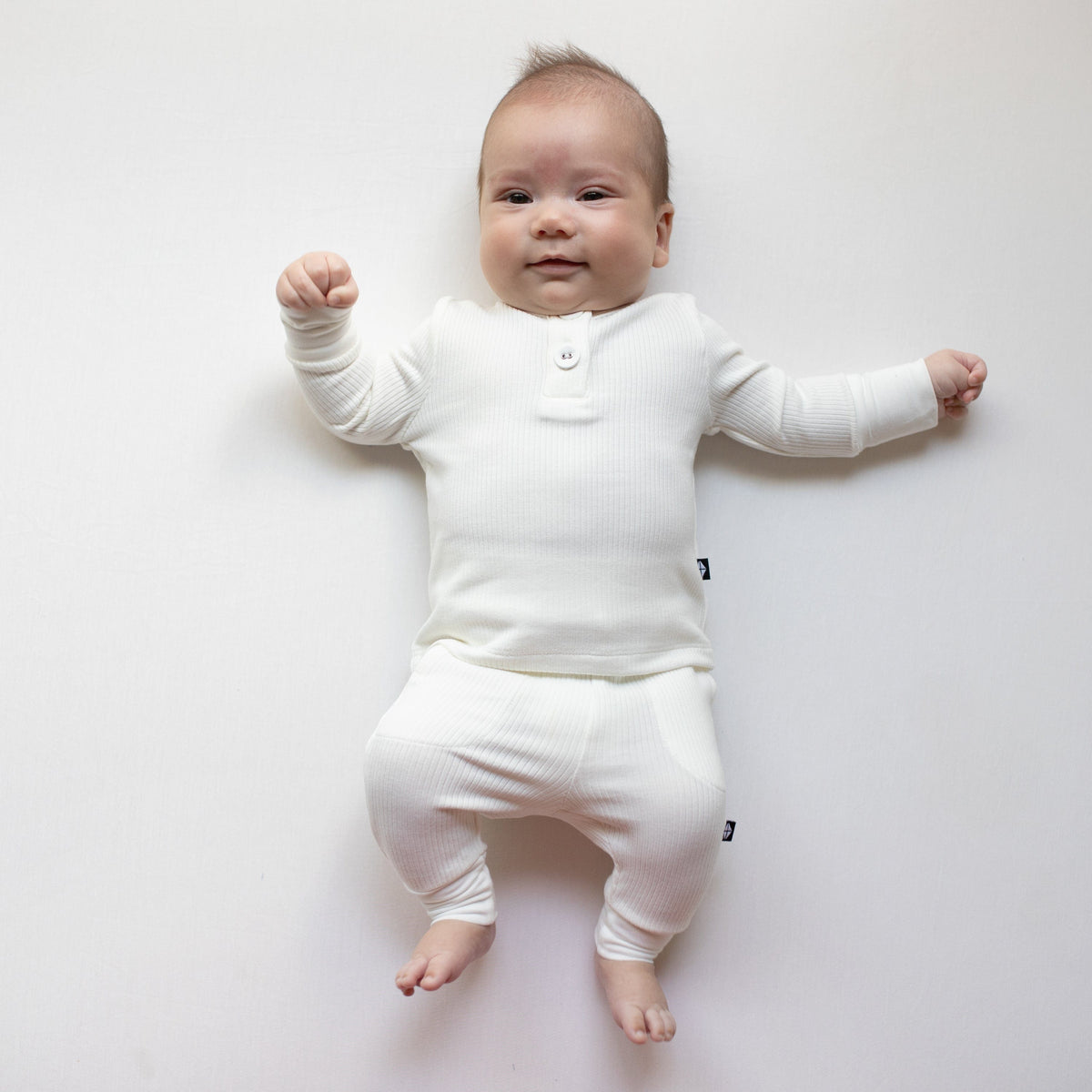 Smiling infant wearing two piece Kyte Baby Ribbed Infant Henley Set in Cloud