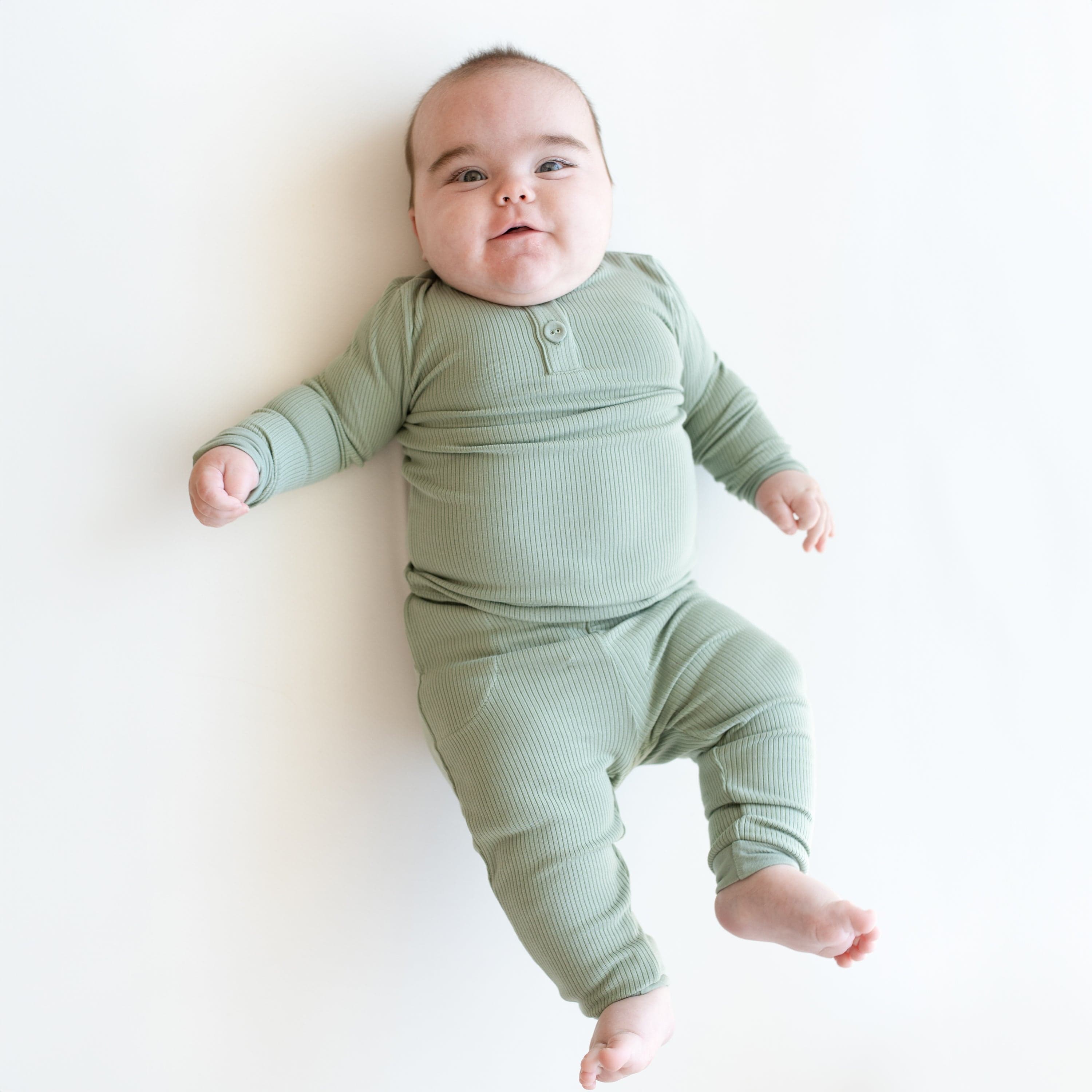 Child wearing Kyte Baby Bamboo Ribbed Infant Henley Set in Thyme green