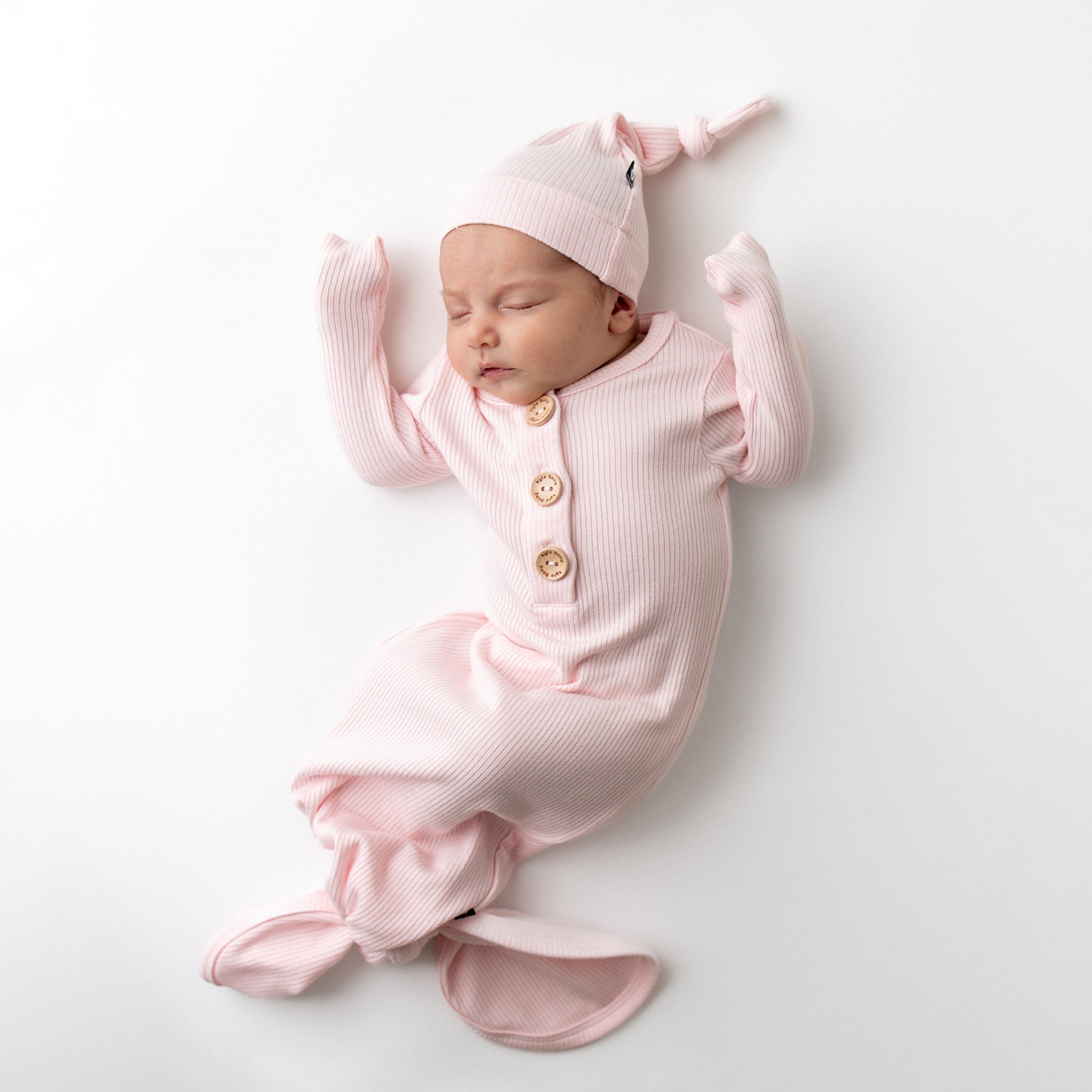 Newborn wearing Kyte Baby bamboo Ribbed Knotted Gown with Hat Set in Sakura