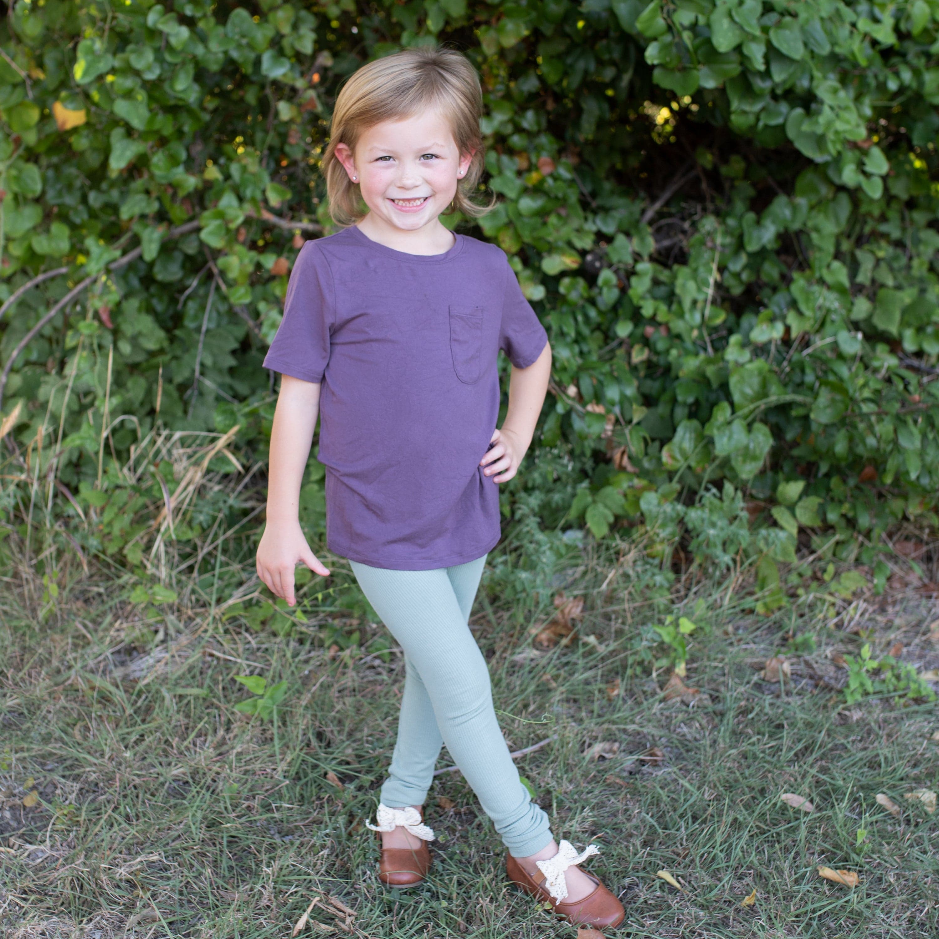Child wearing Kyte Baby Ribbed Bamboo Leggings in Thyme green
