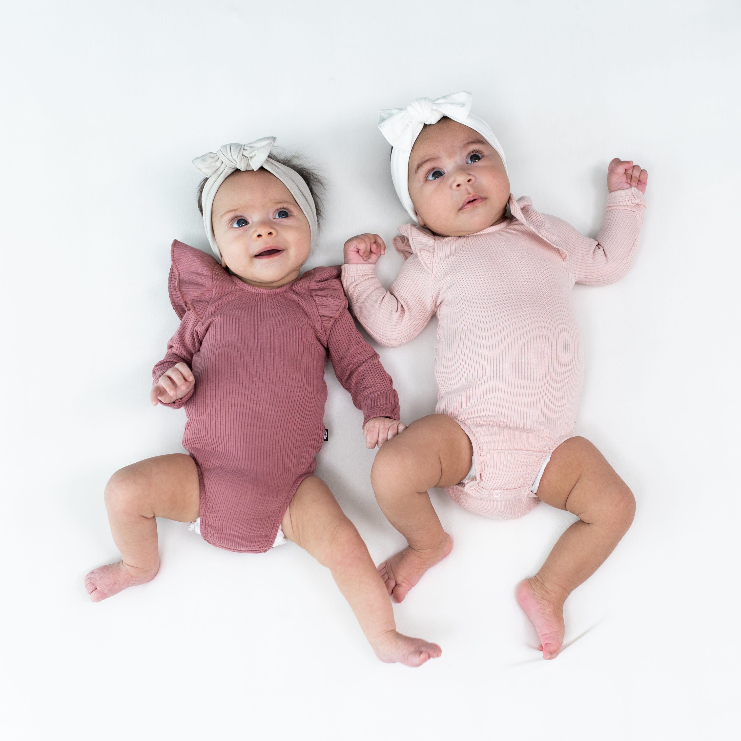 Babies wearing Kyte Baby Ribbed Long Sleeve Ruffle Leotards