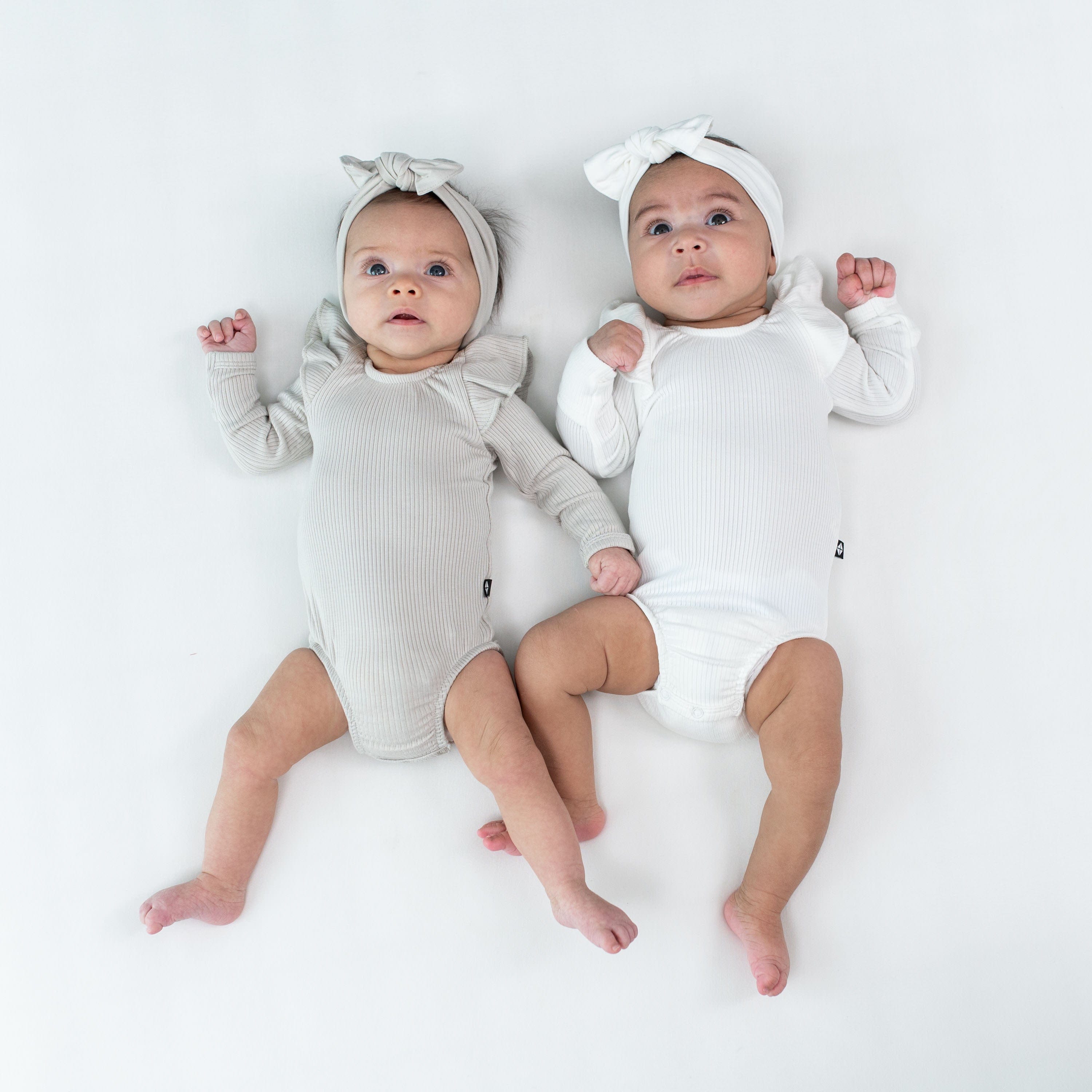 Babies wearing Kyte Baby Ribbed Long Sleeve Ruffle Leotards