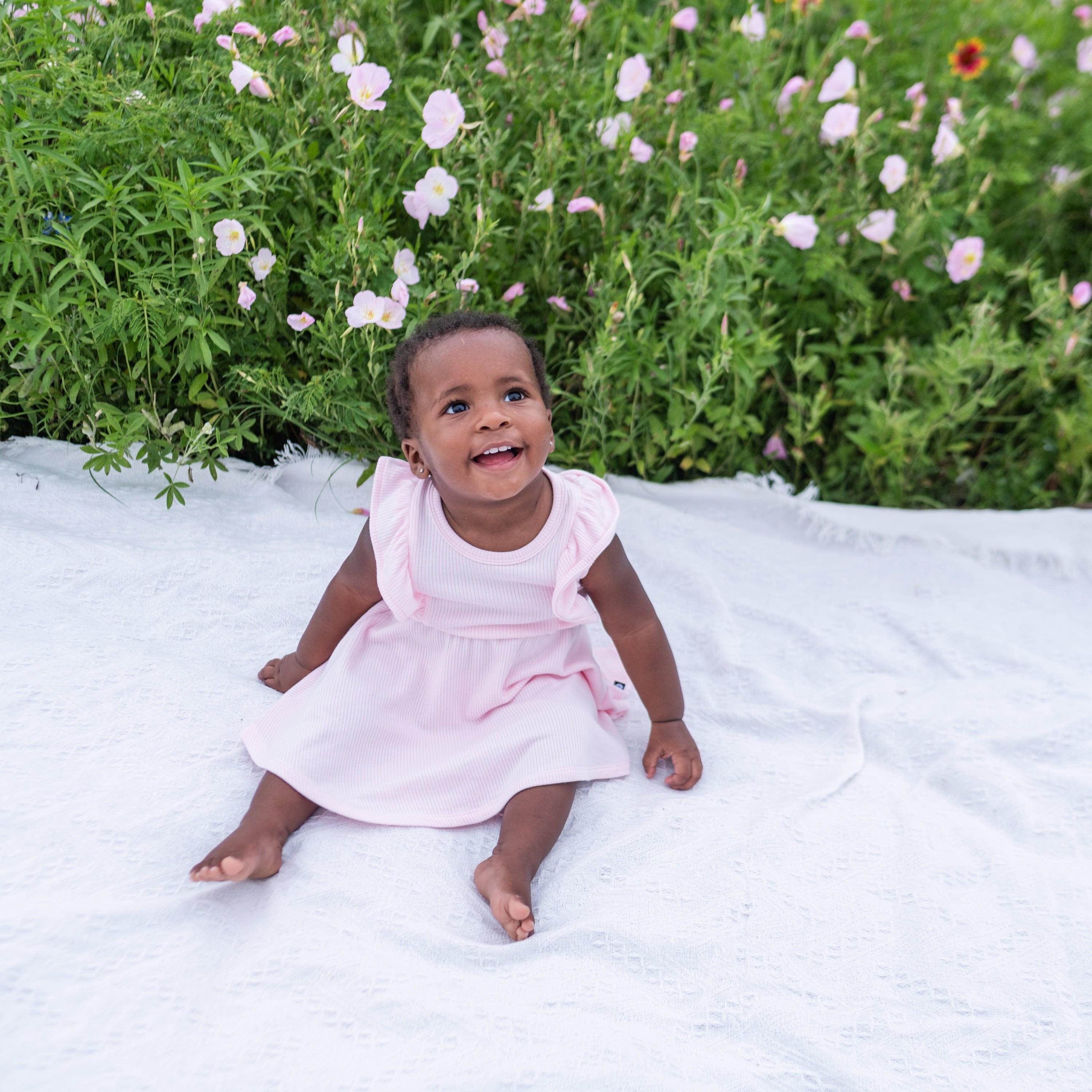 Girl wearing Kyte Baby Ribbed Peplum Dress Set with Flutter Sleeves in Sakura