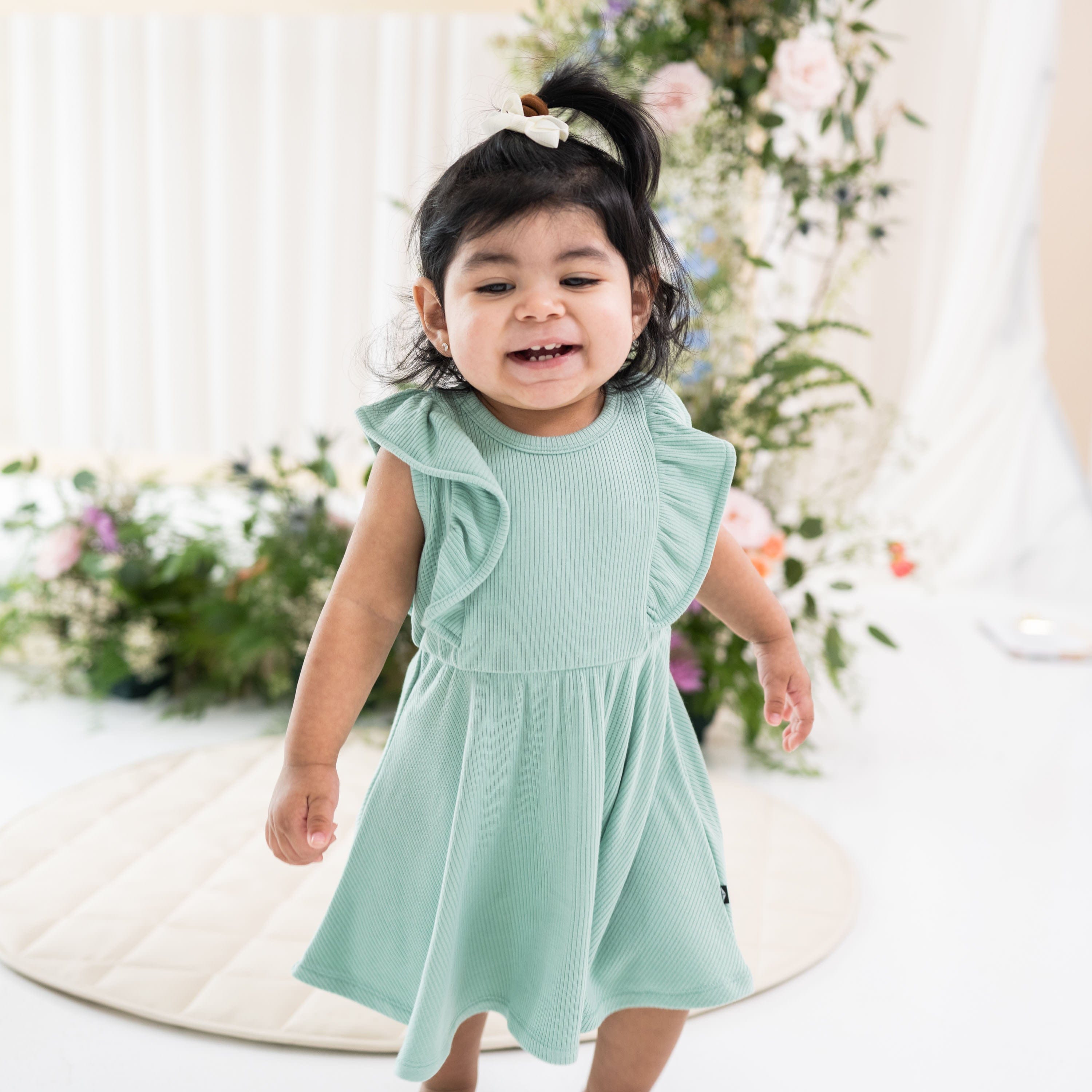 Toddler wearing Kyte Baby Ribbed Peplum Dress Set in Wasabi green