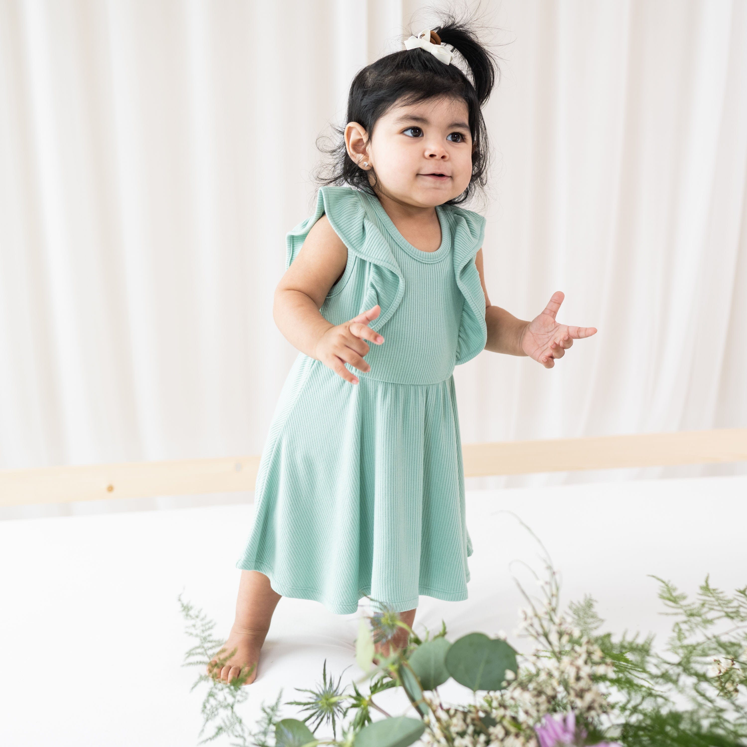 Child wearing Kyte Baby Bamboo Ribbed Peplum Dress Set in Wasabi