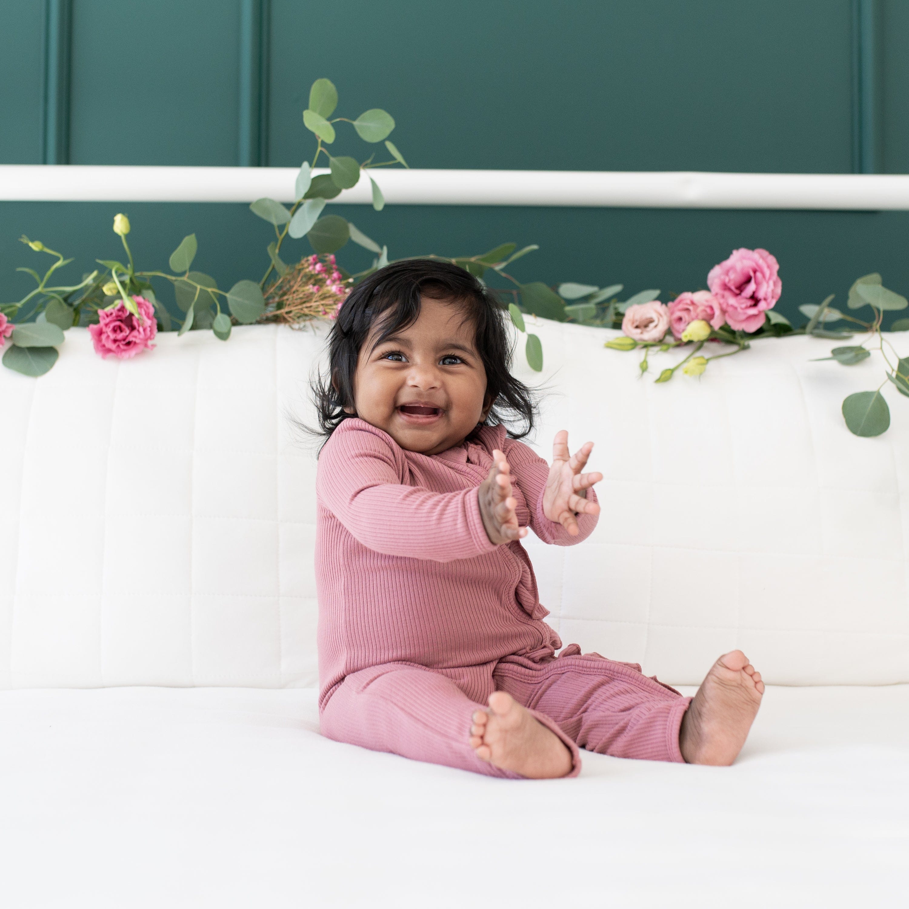 Toddler wearing Kyte Baby Ribbed Ruffle Zipper Romper in Dusty Rose