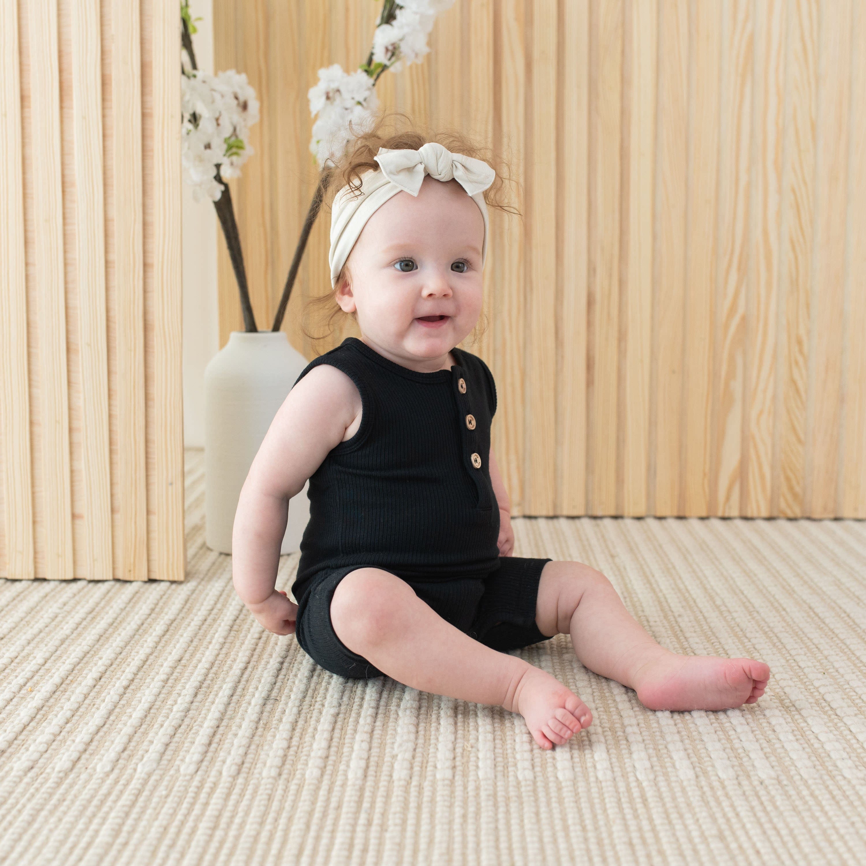 Infant wearing Kyte Baby Ribbed Sleeveless Shortall in Midnight