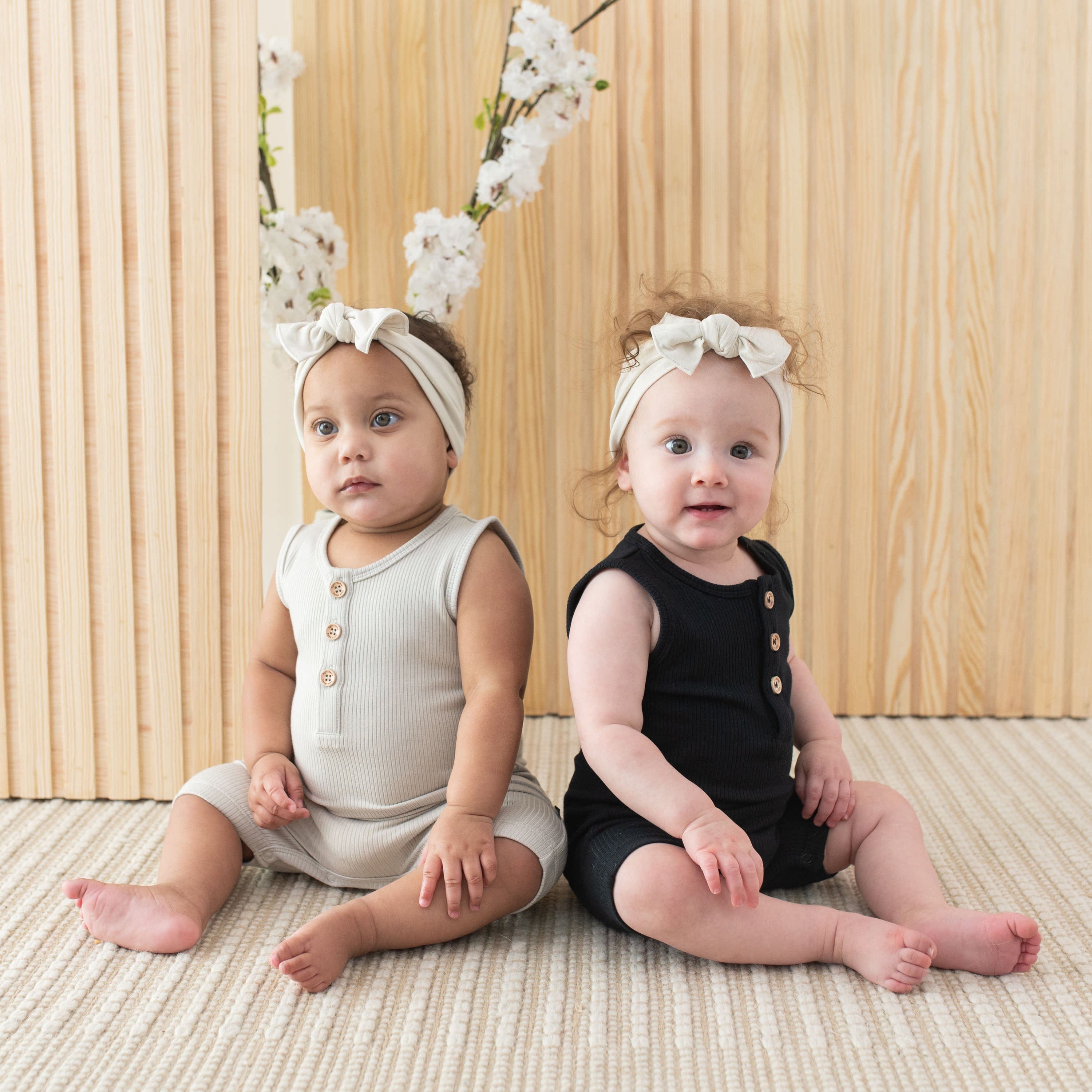Infants wearing Kyte Baby Ribbed Sleeveless Shortalls with henley neckline