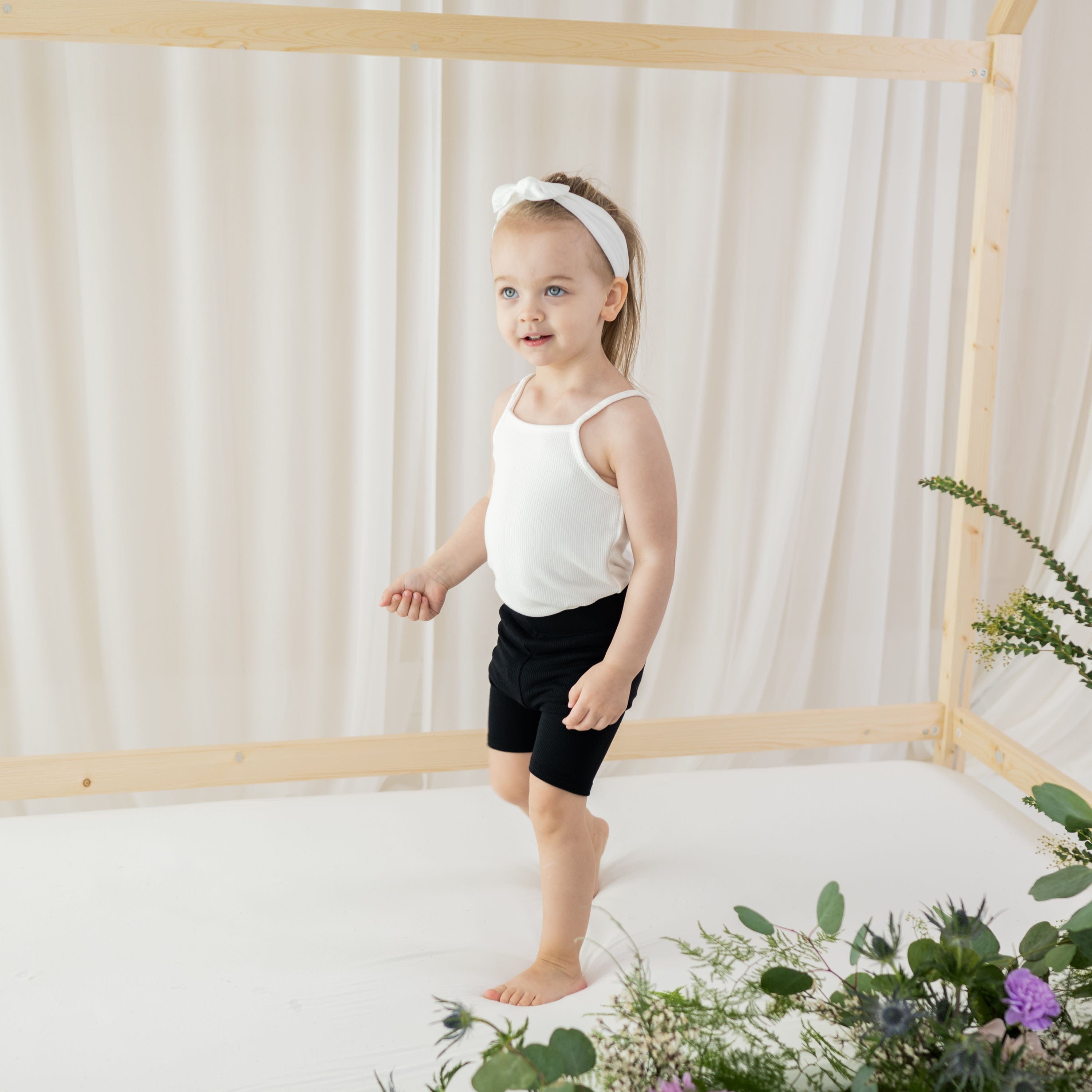 Child wearing Kyte Baby bamboo Ribbed Spaghetti Strap Bodysuit in Cloud