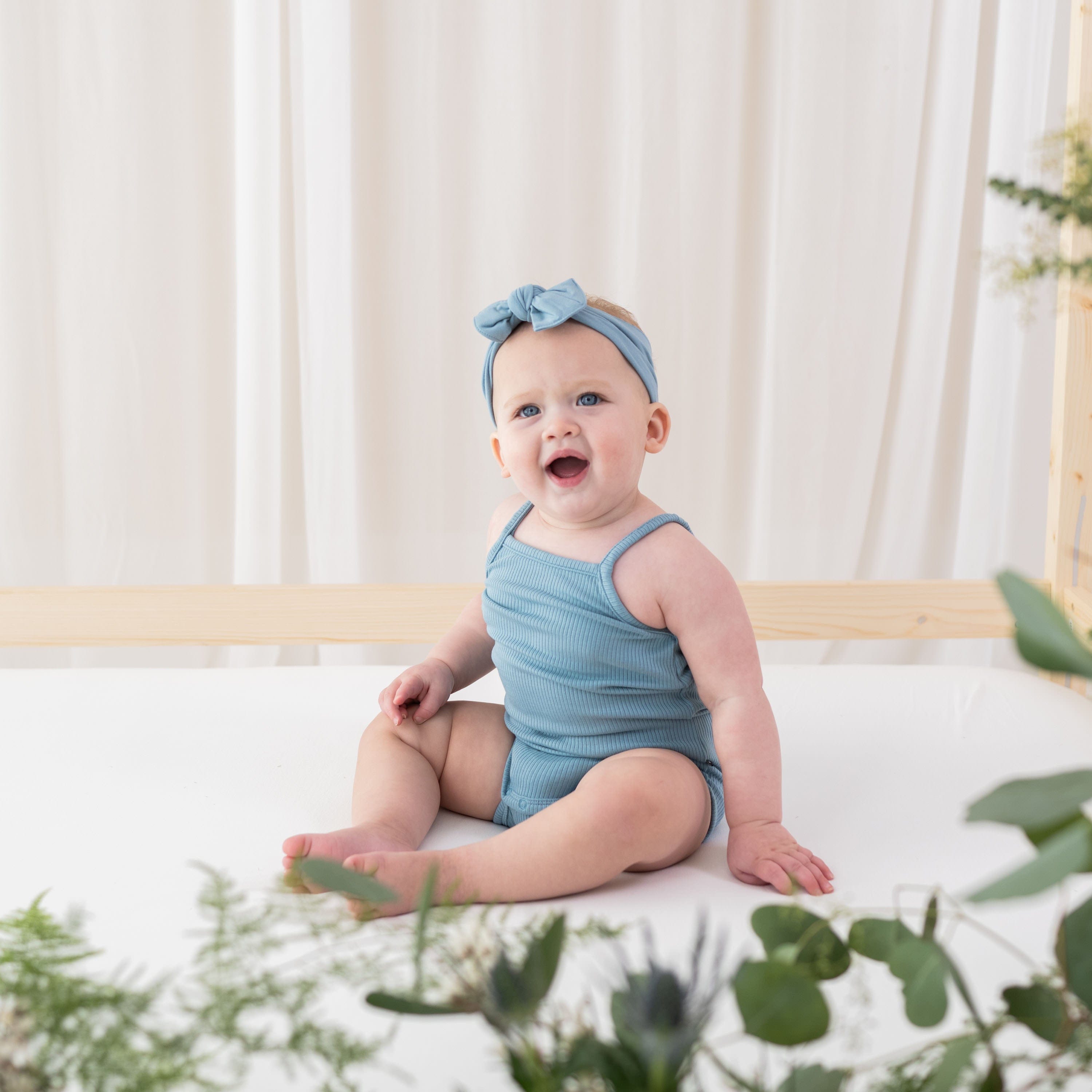 Infant wearing Kyte Baby Ribbed Spaghetti Strap Bodysuit in Dusty Blue