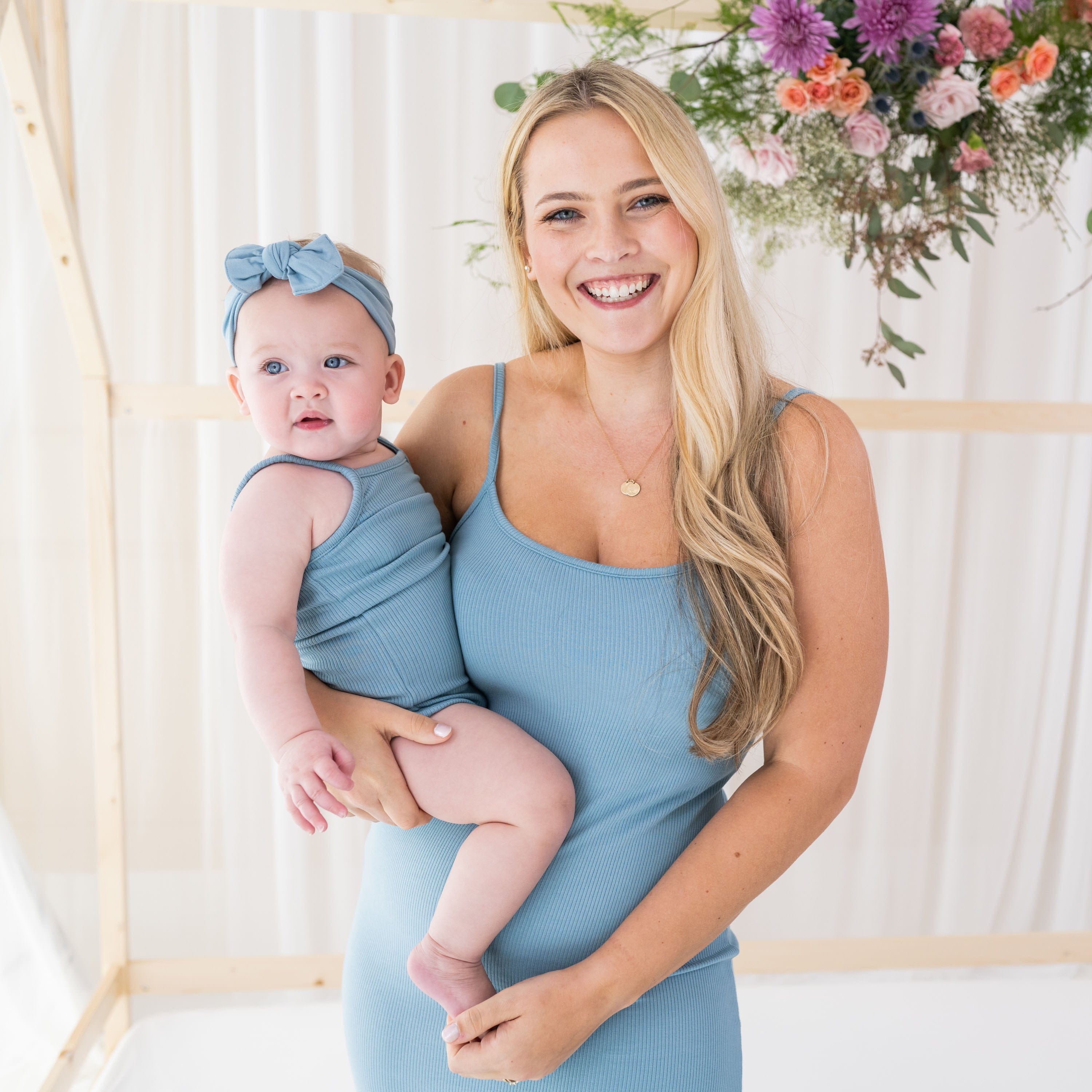 Mom with Infant in matching Kyte Baby ribbed outfits in Dusty Blue