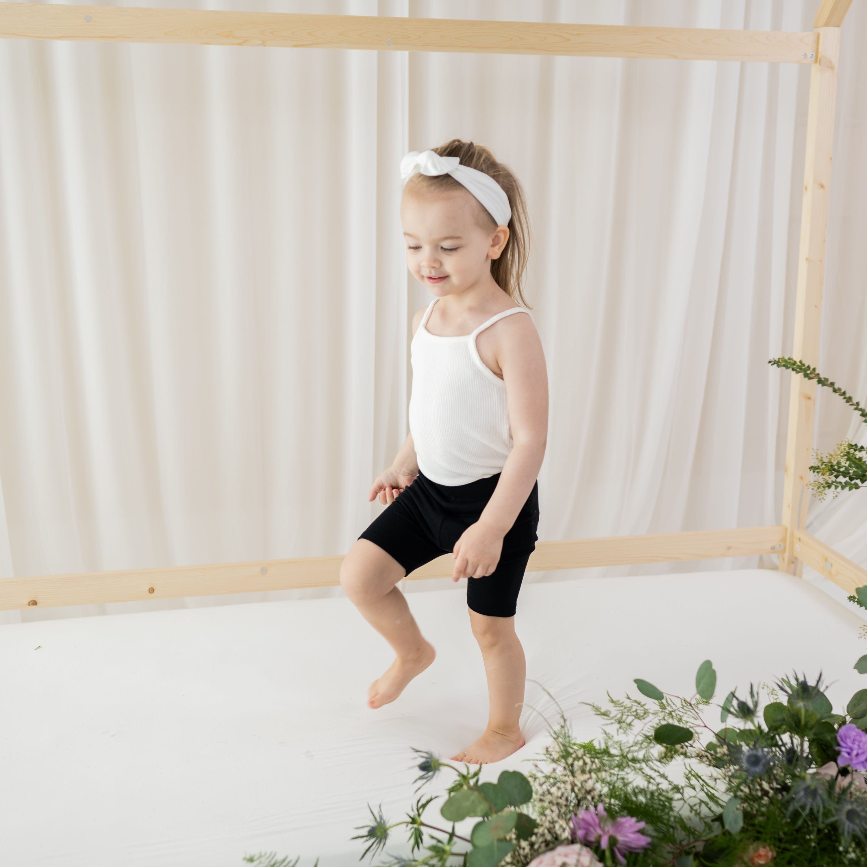 Girl wearing Kyte Baby Ribbed Toddler Bike Shorts in Midnight Black