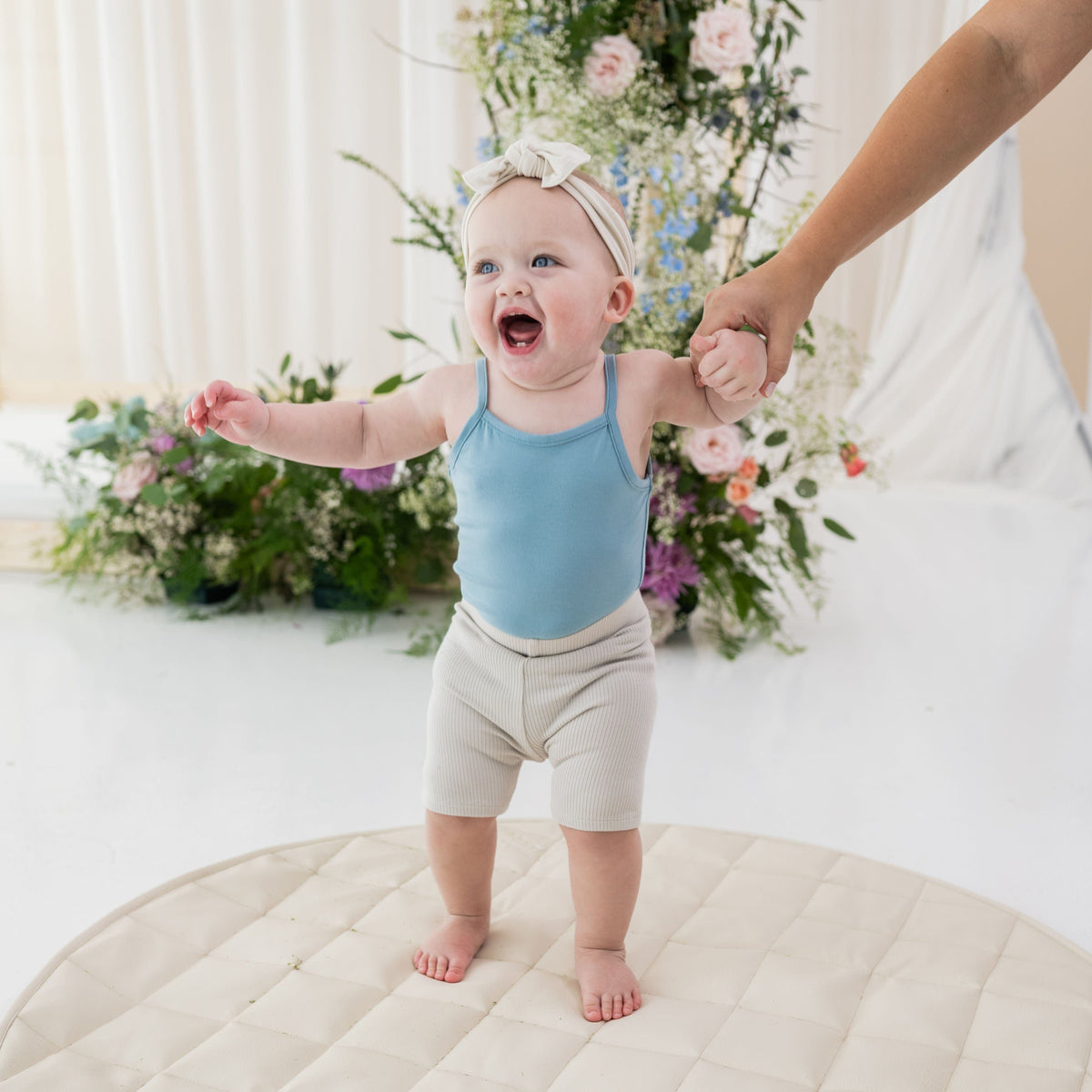 Infant wearing Kyte Baby Ribbed Biker Shorts in Oat