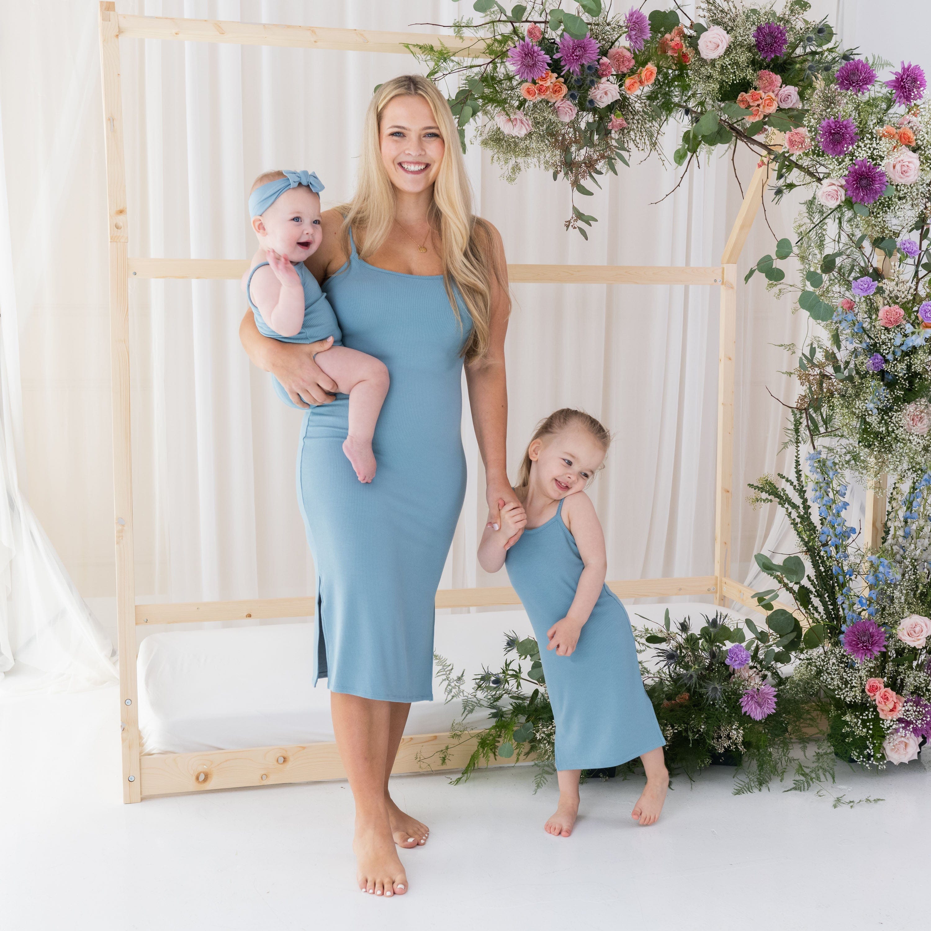 Mom and children in matching Kyte Baby dresses in Dusty Blue