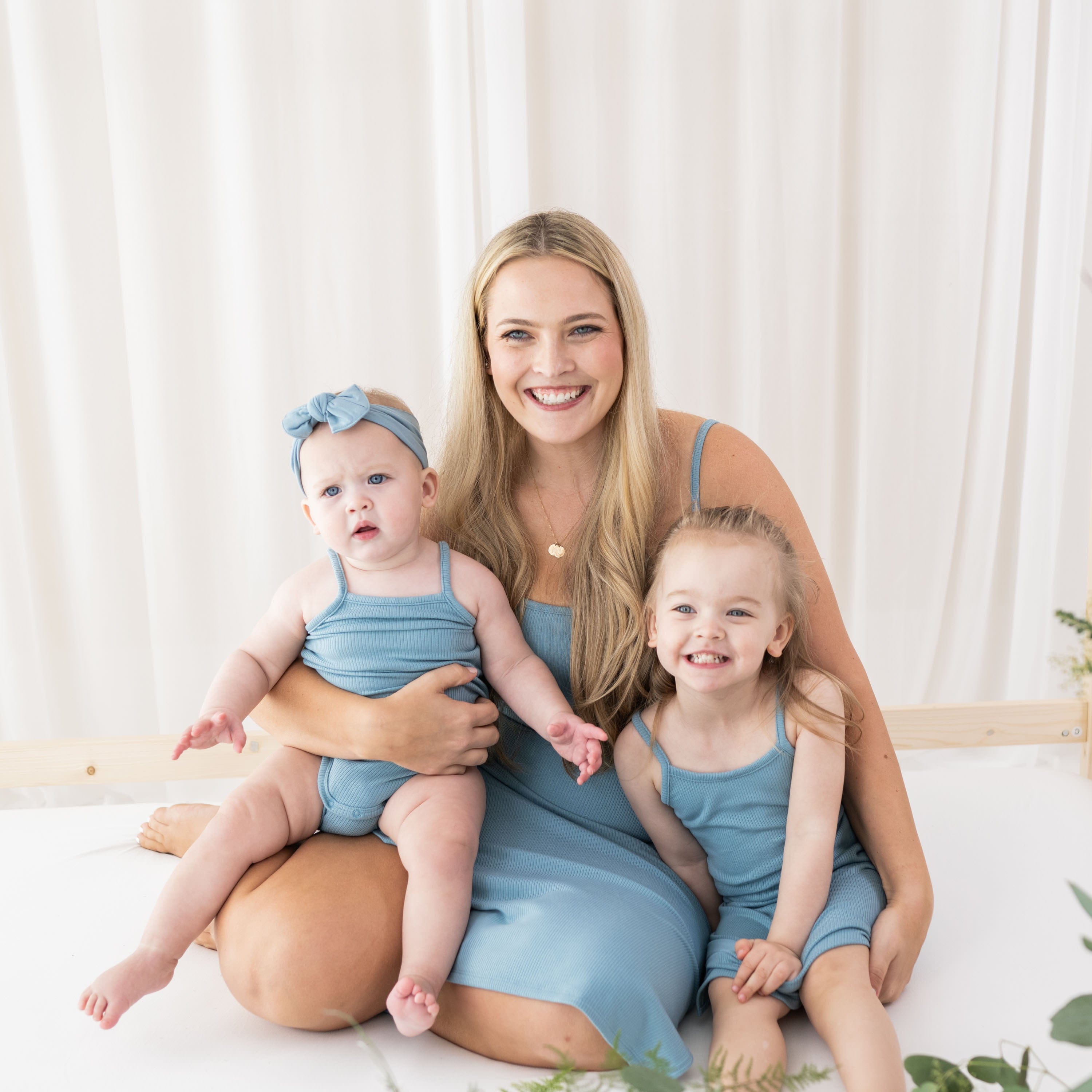 Models wearing Kyte Baby mommy and me dresses in Dusty Blue