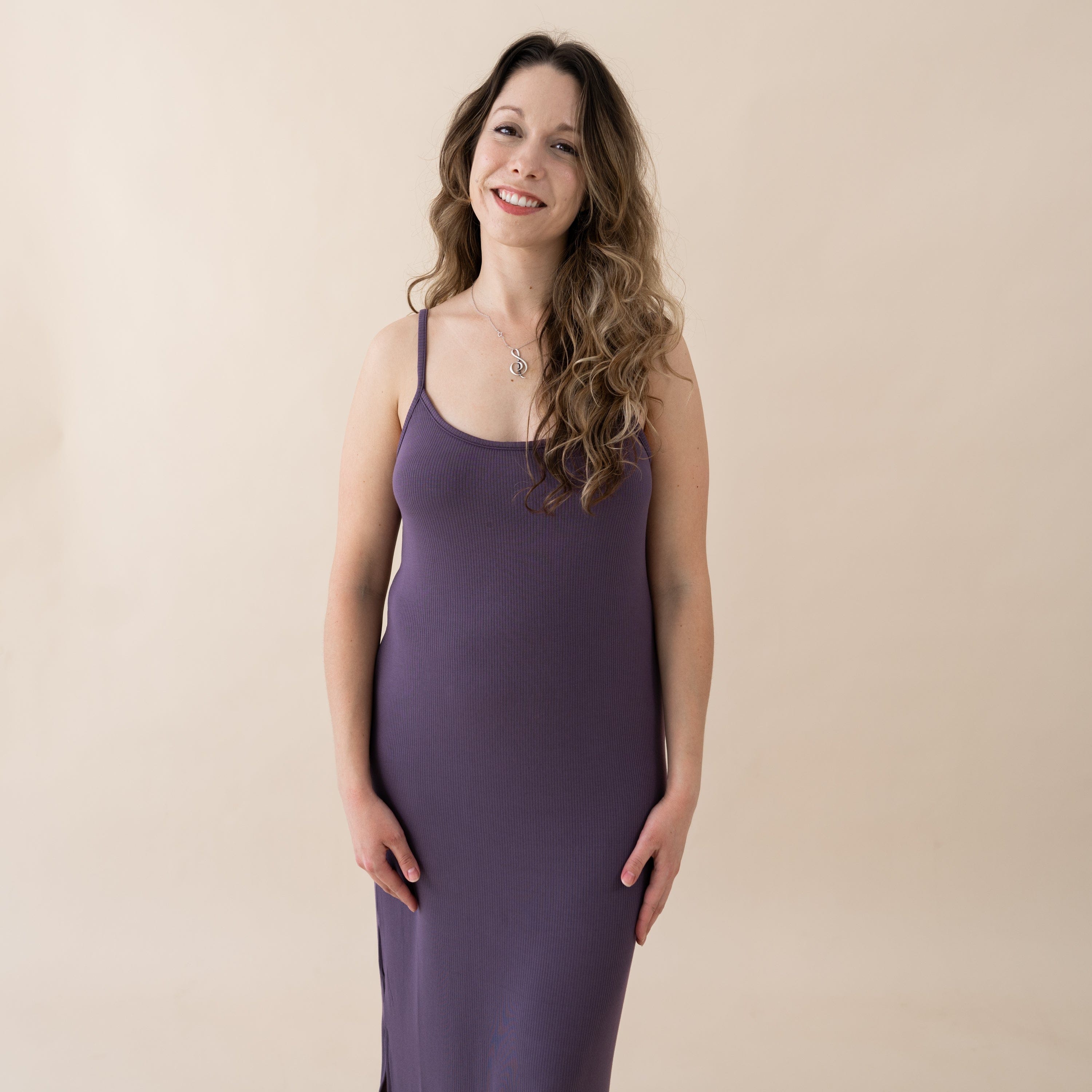 Woman wearing Kyte Baby midi length Cami Dress in Currant purple