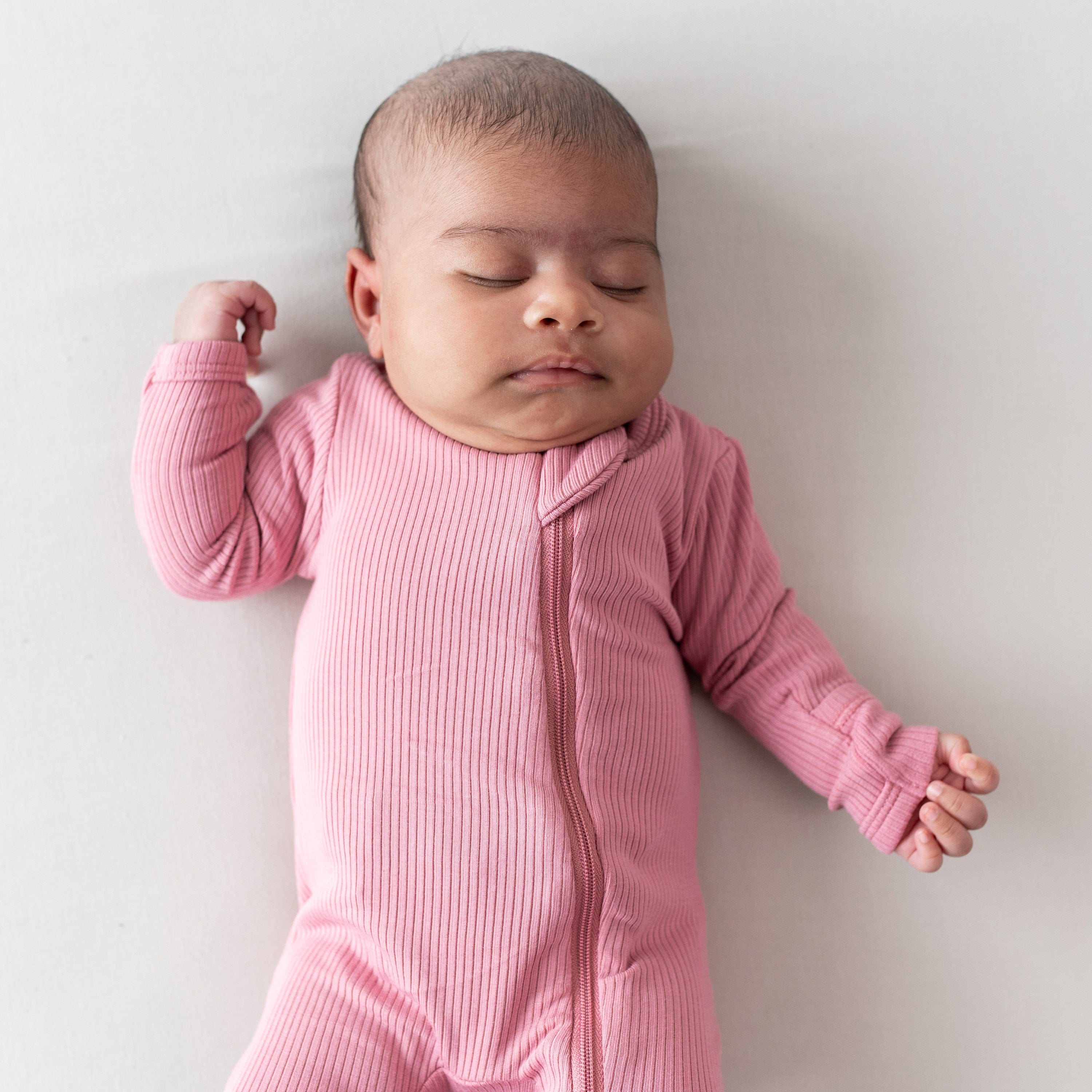 Infant wearing Ribbed Zipper Footie Kids Pink Pajamas in Apple Blossom