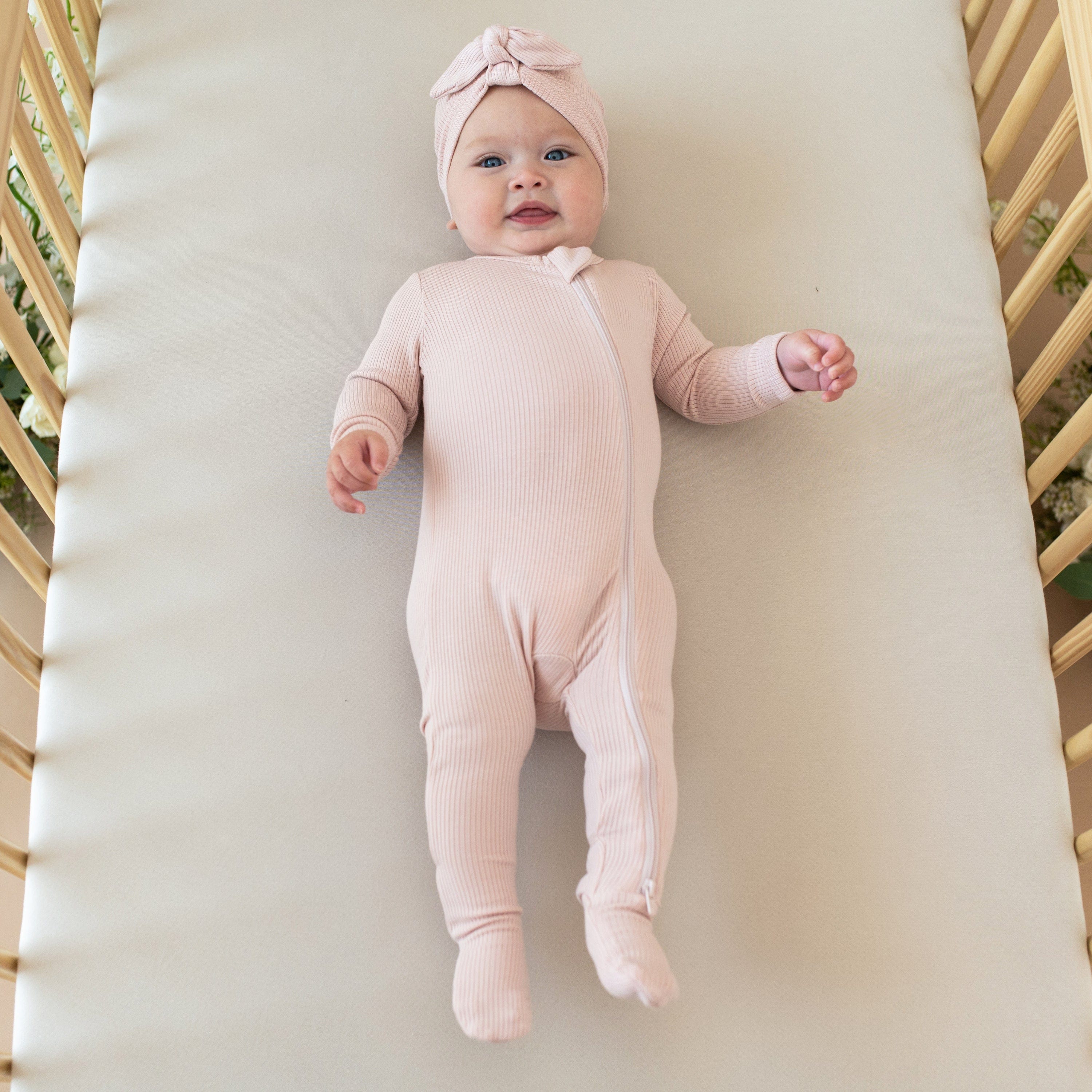 Baby wearing Kyte Baby Ribbed Zippered Footie in Blush