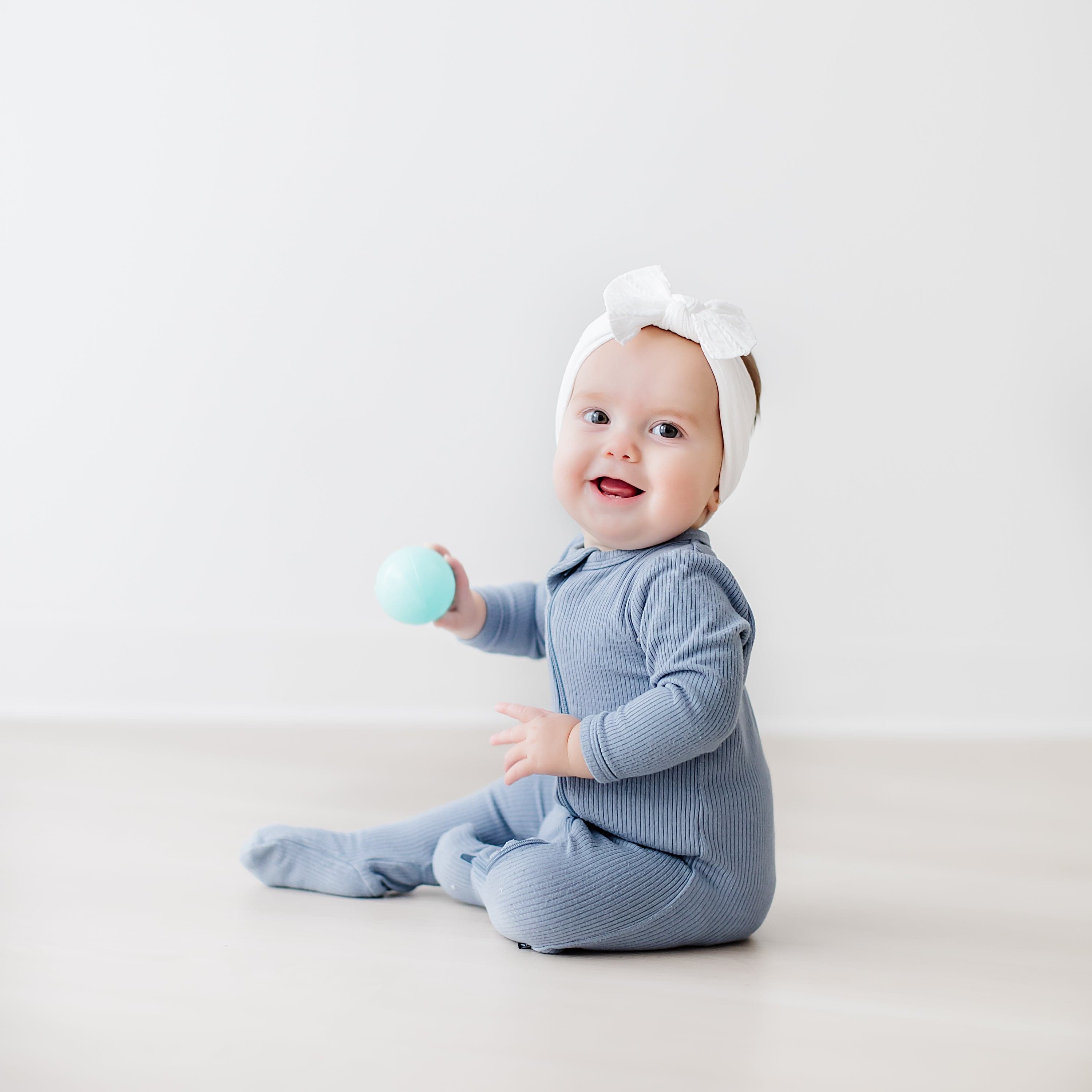 Baby wearing Kyte Baby bamboo Ribbed Zippered Footie in Slate