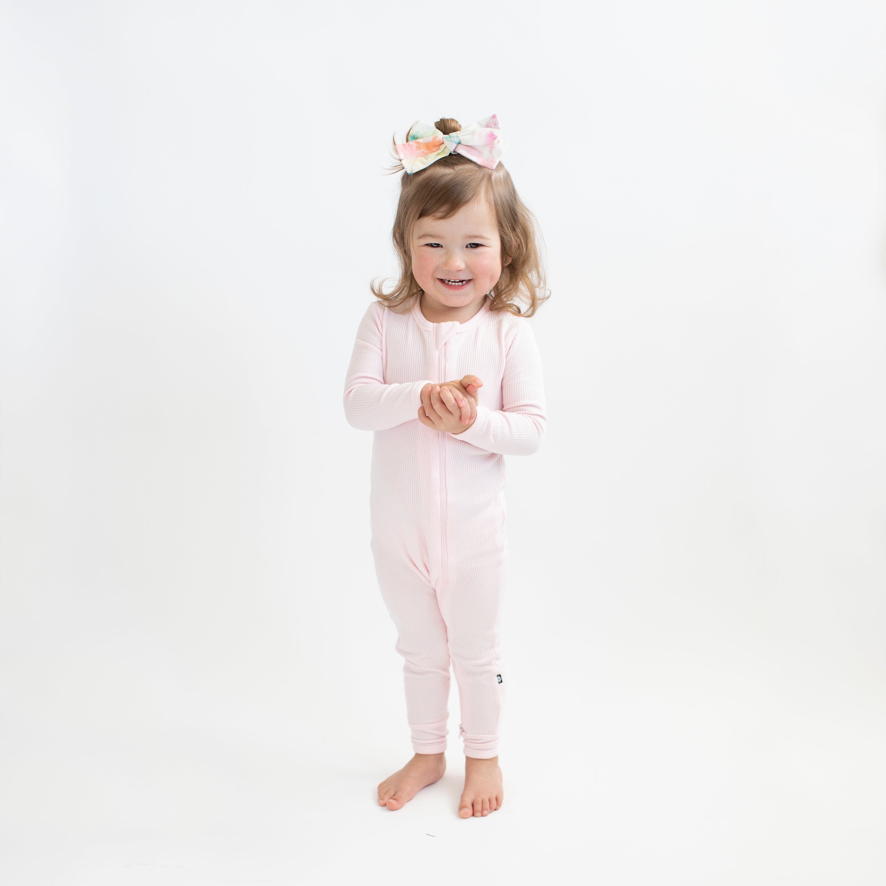 Toddler wearing Kyte Baby Ribbed Zippered Romper in Sakura