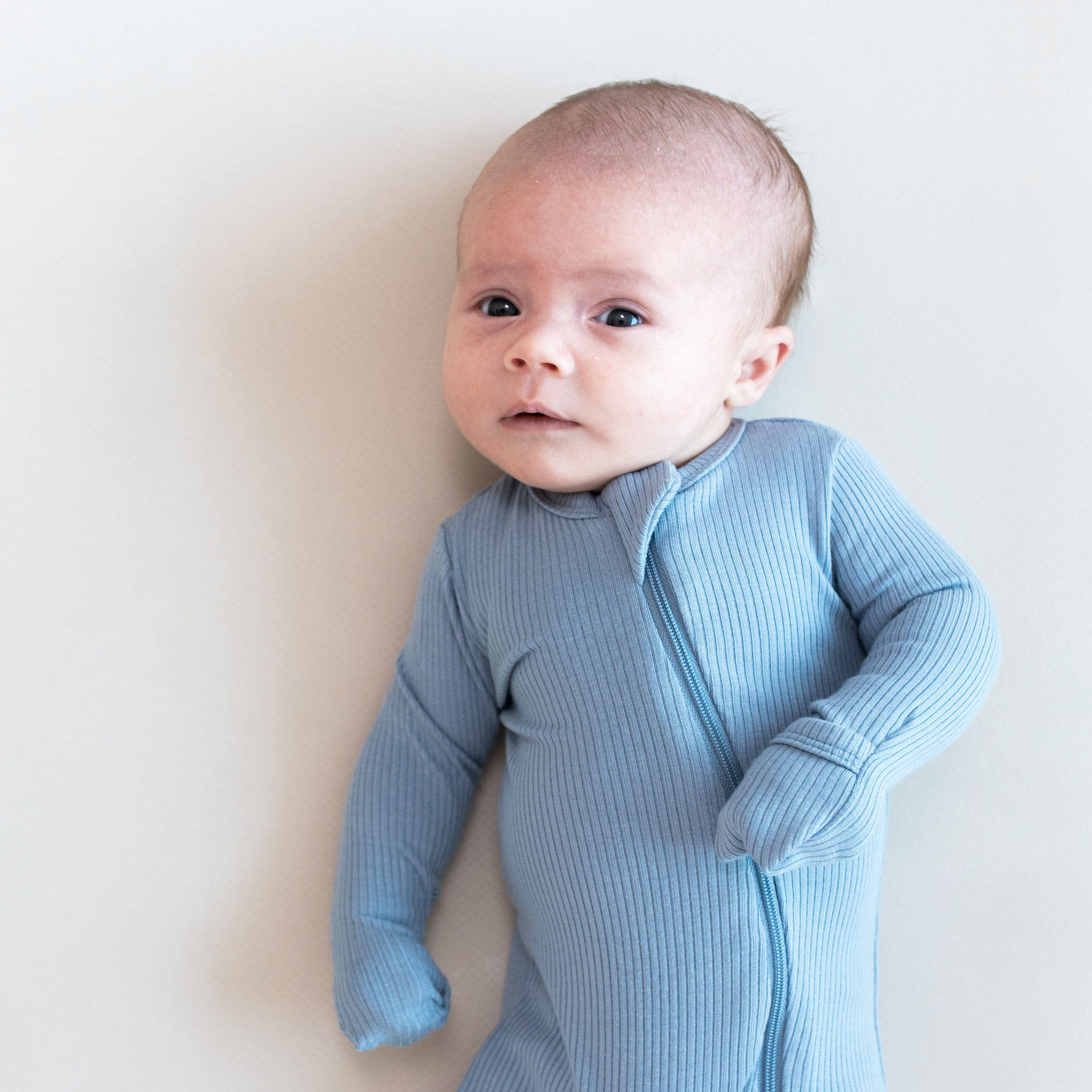 Infant wearing Kyte Baby Ribbed Zippered Romper in Slate