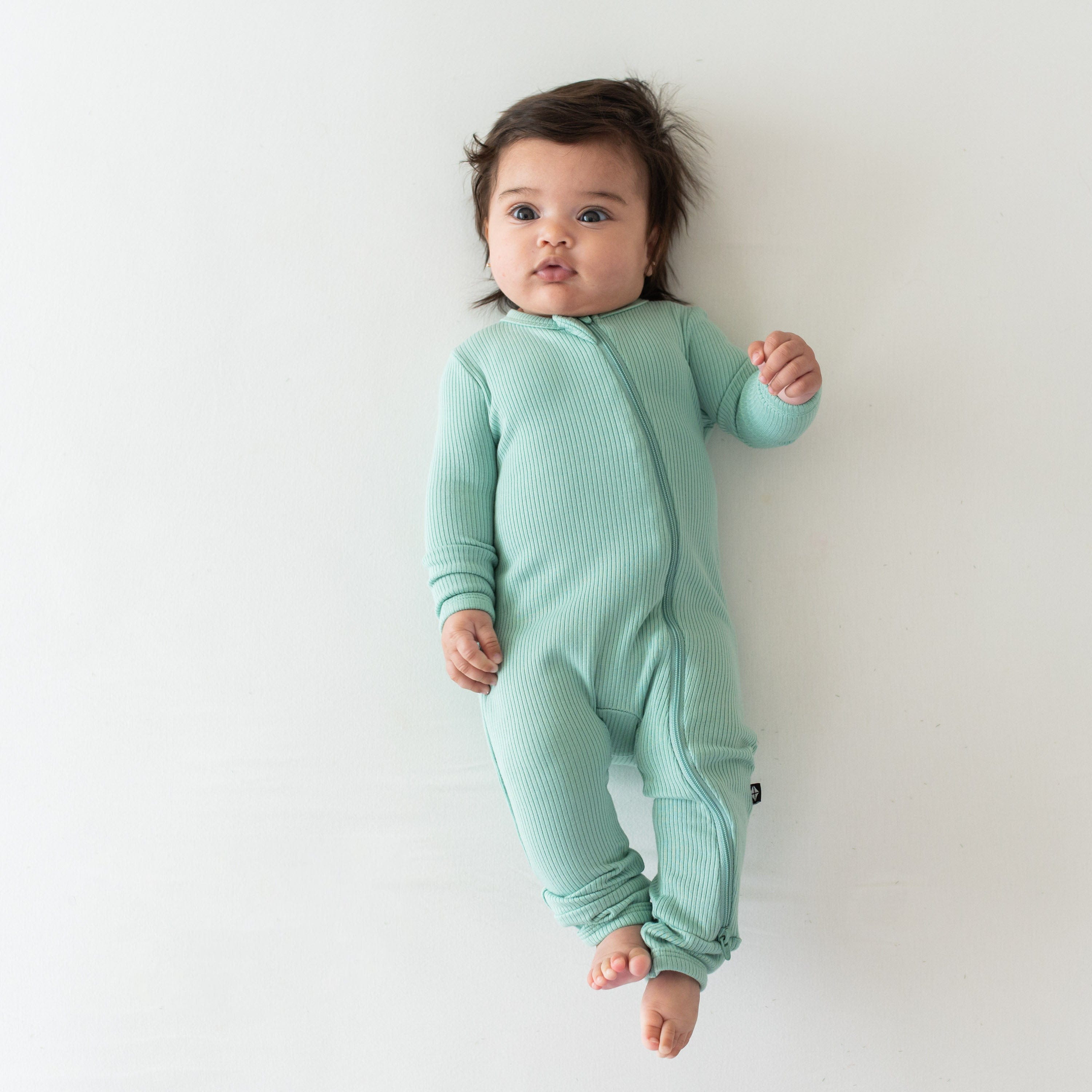 Infant wearing Kyte Baby Ribbed Zippered Romper in Wasabi