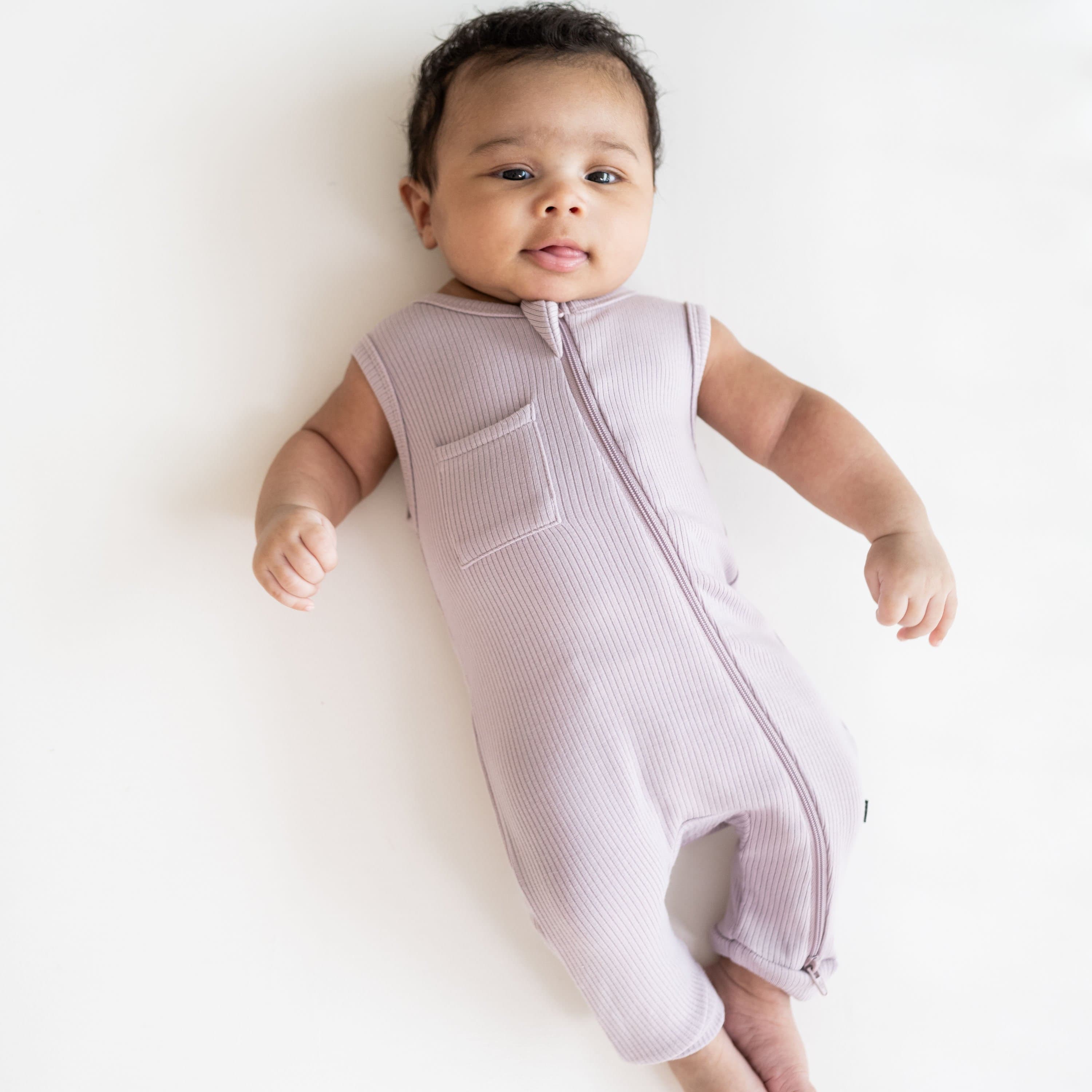 Newborn wearing Kyte Baby bamboo Ribbed Zippered Sleeveless Romper in Wisteria