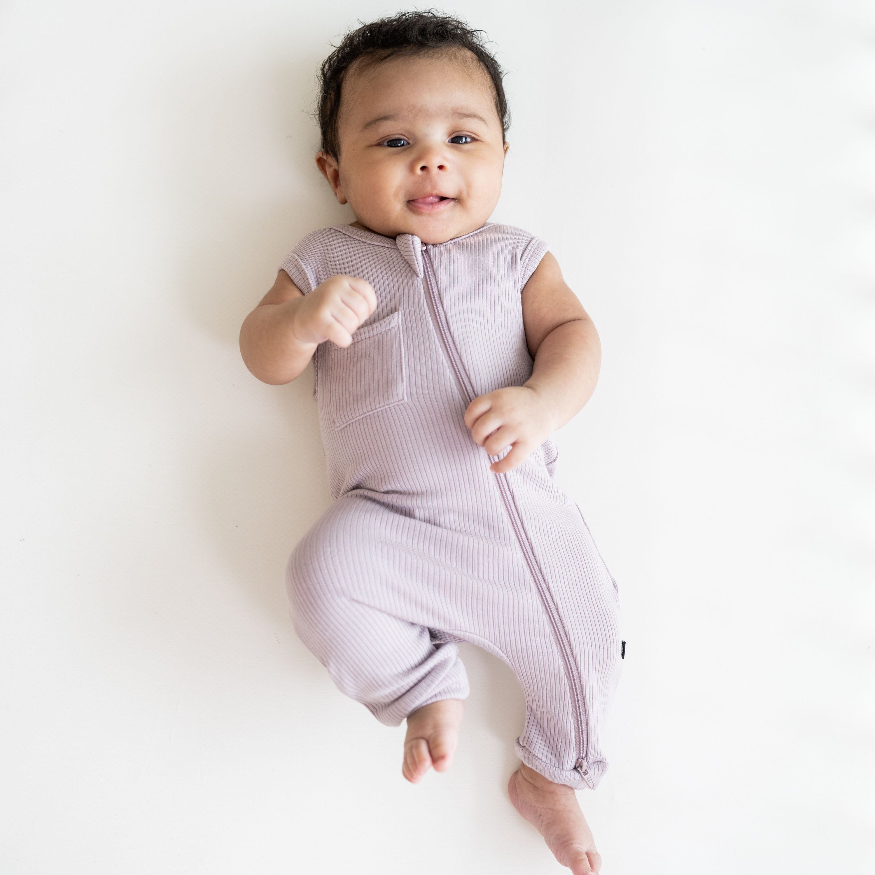 Infant wearing Kyte Baby Ribbed Zippered Sleeveless Romper in Wisteria