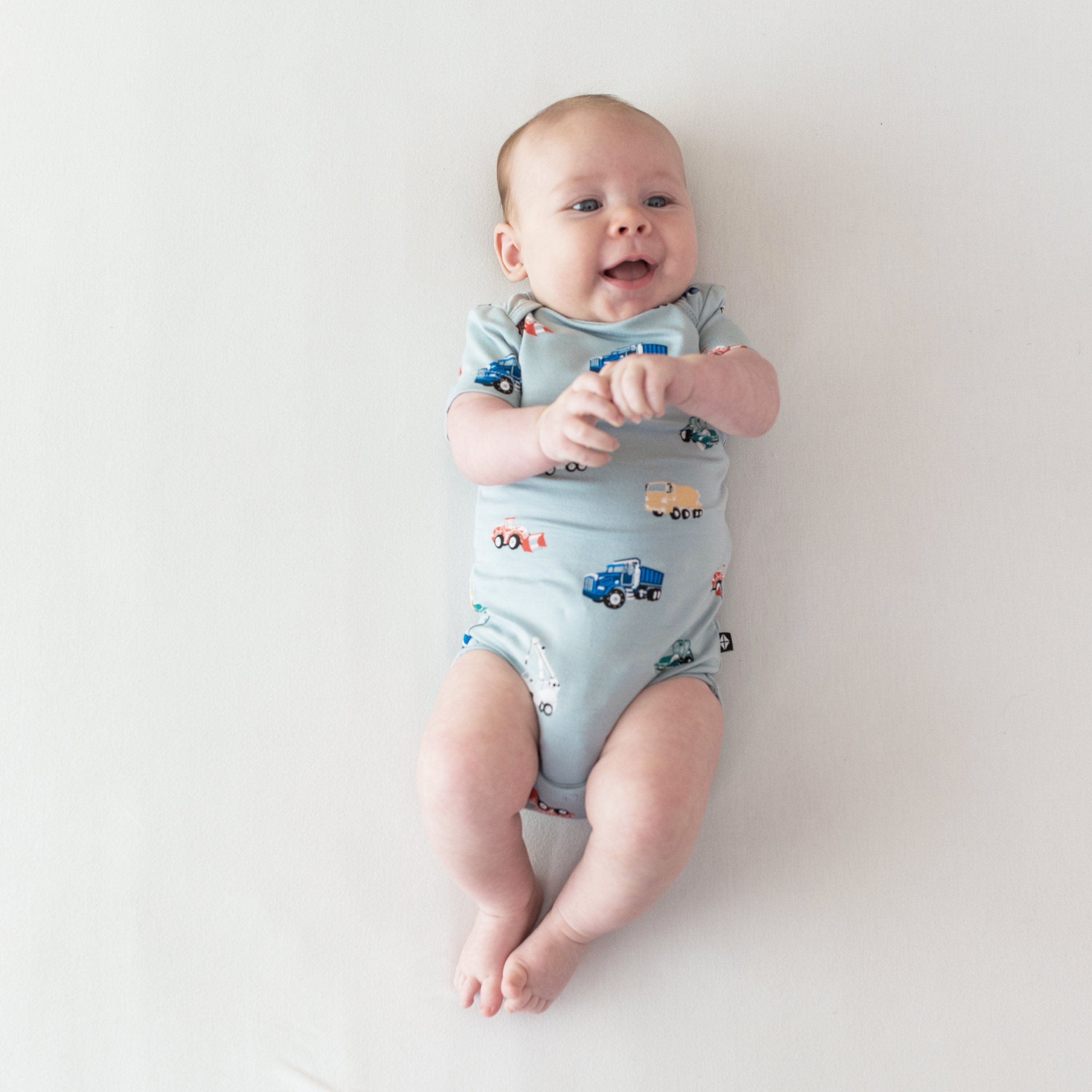 Newborn wearing Kyte Baby Bodysuit in Construction