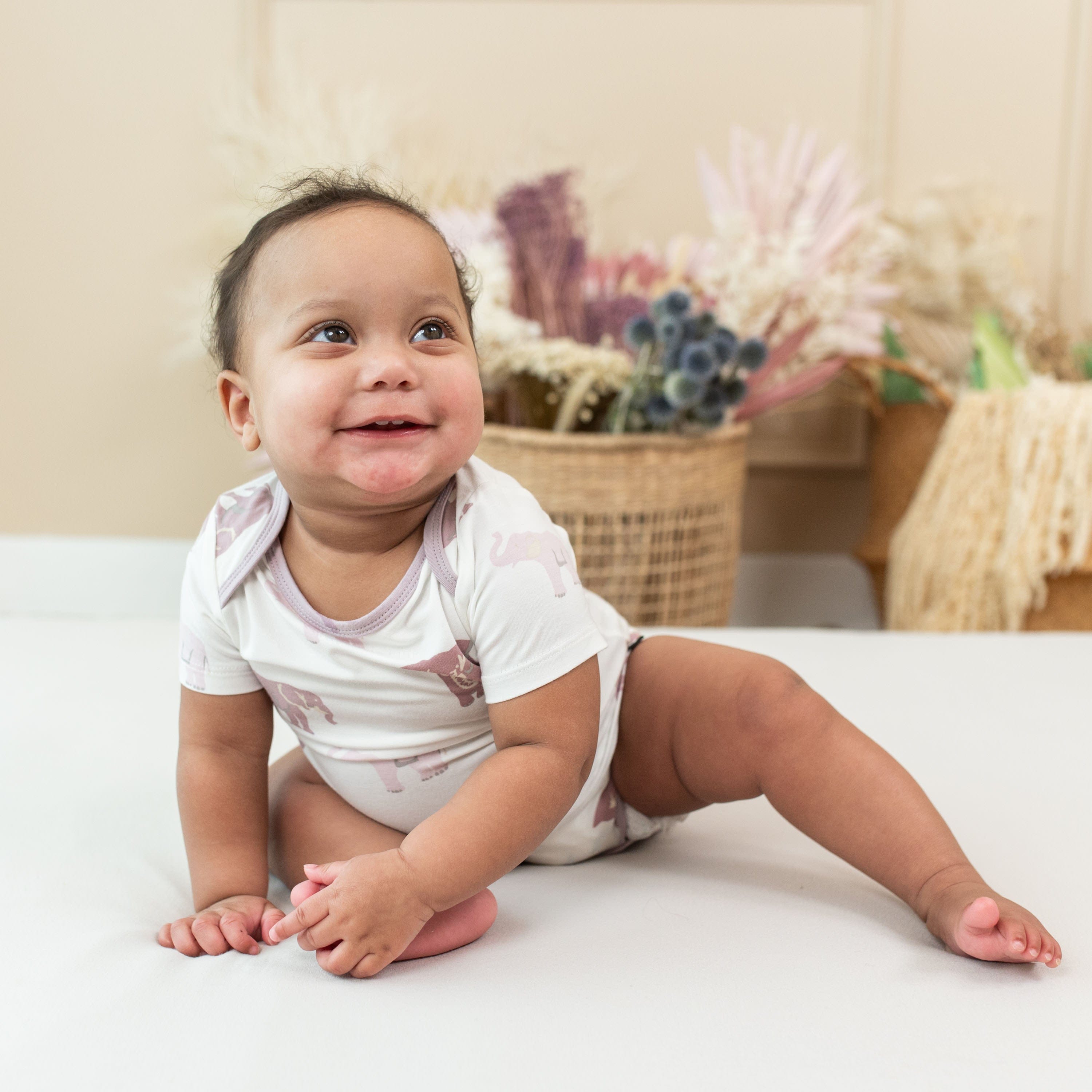 Infant wearing short sleeve Kyte Baby Bodysuit in Elephant