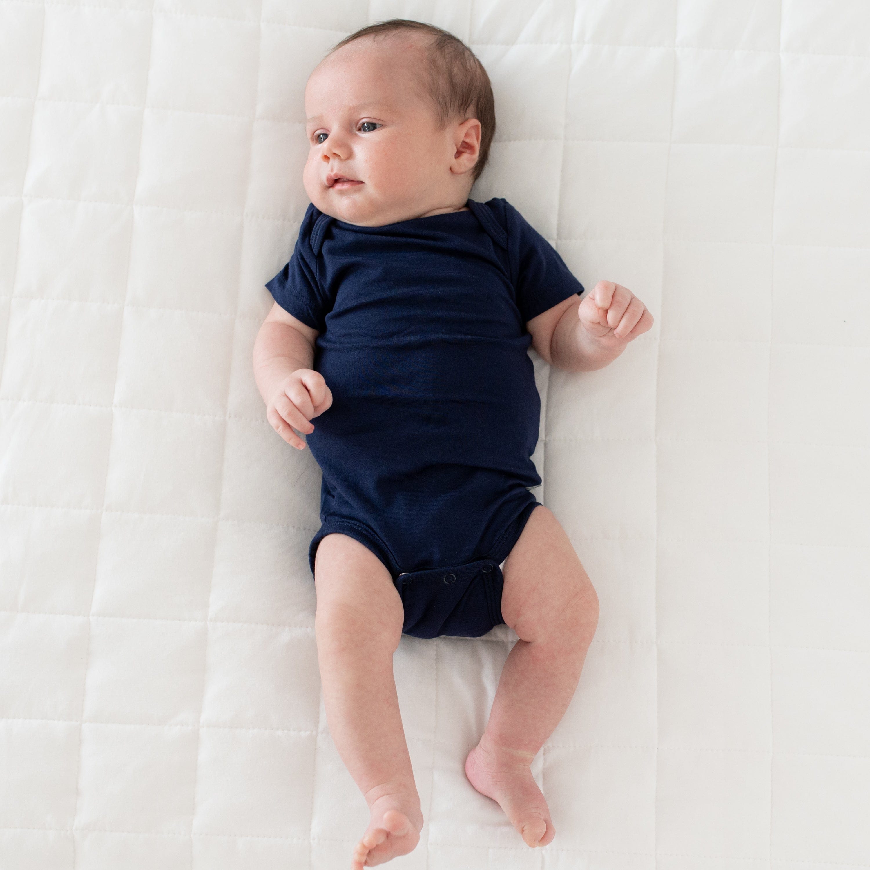 Newborn wearing Kyte Baby Bodysuit in Navy