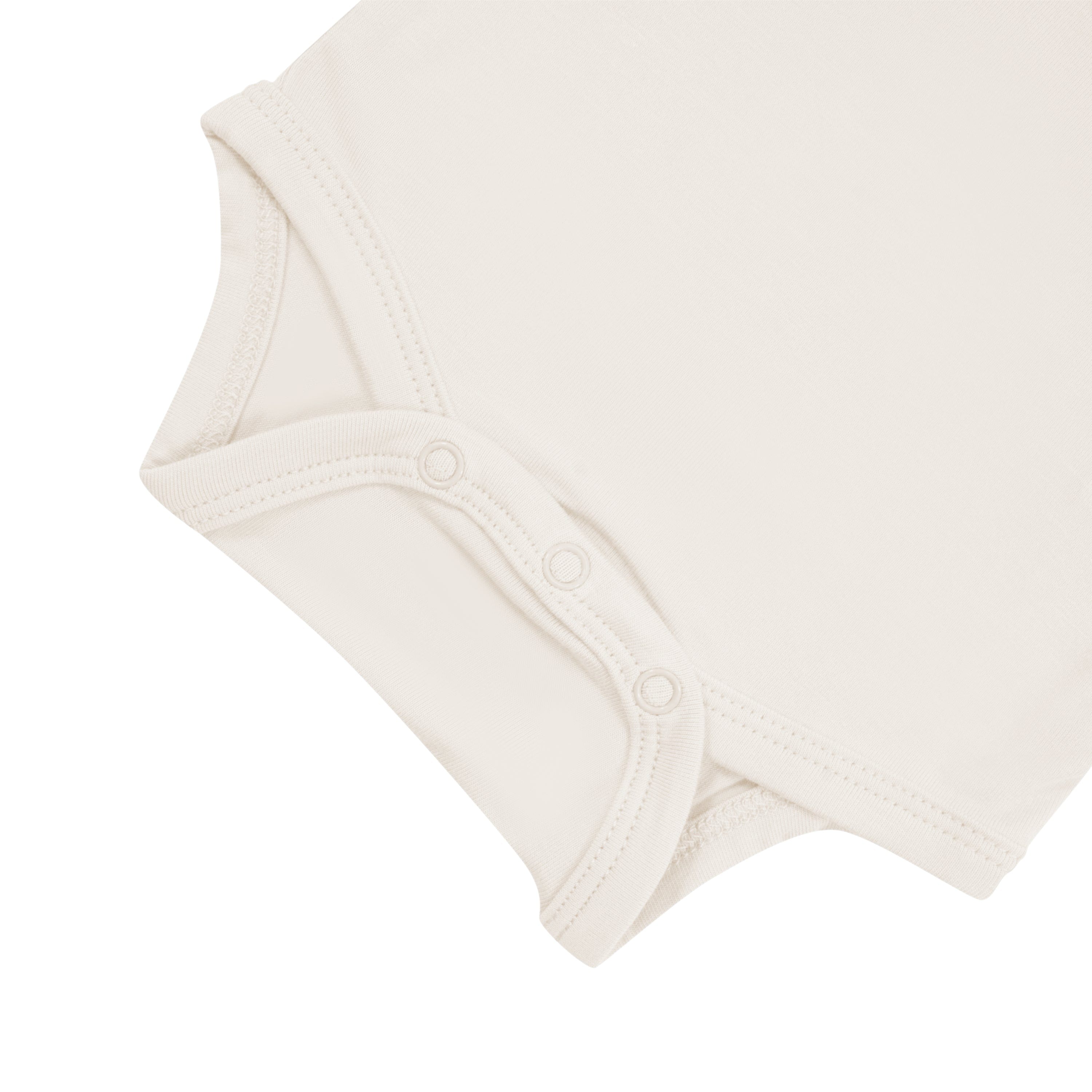 Close up of snap bottom of Kyte Baby Bodysuit in Oat