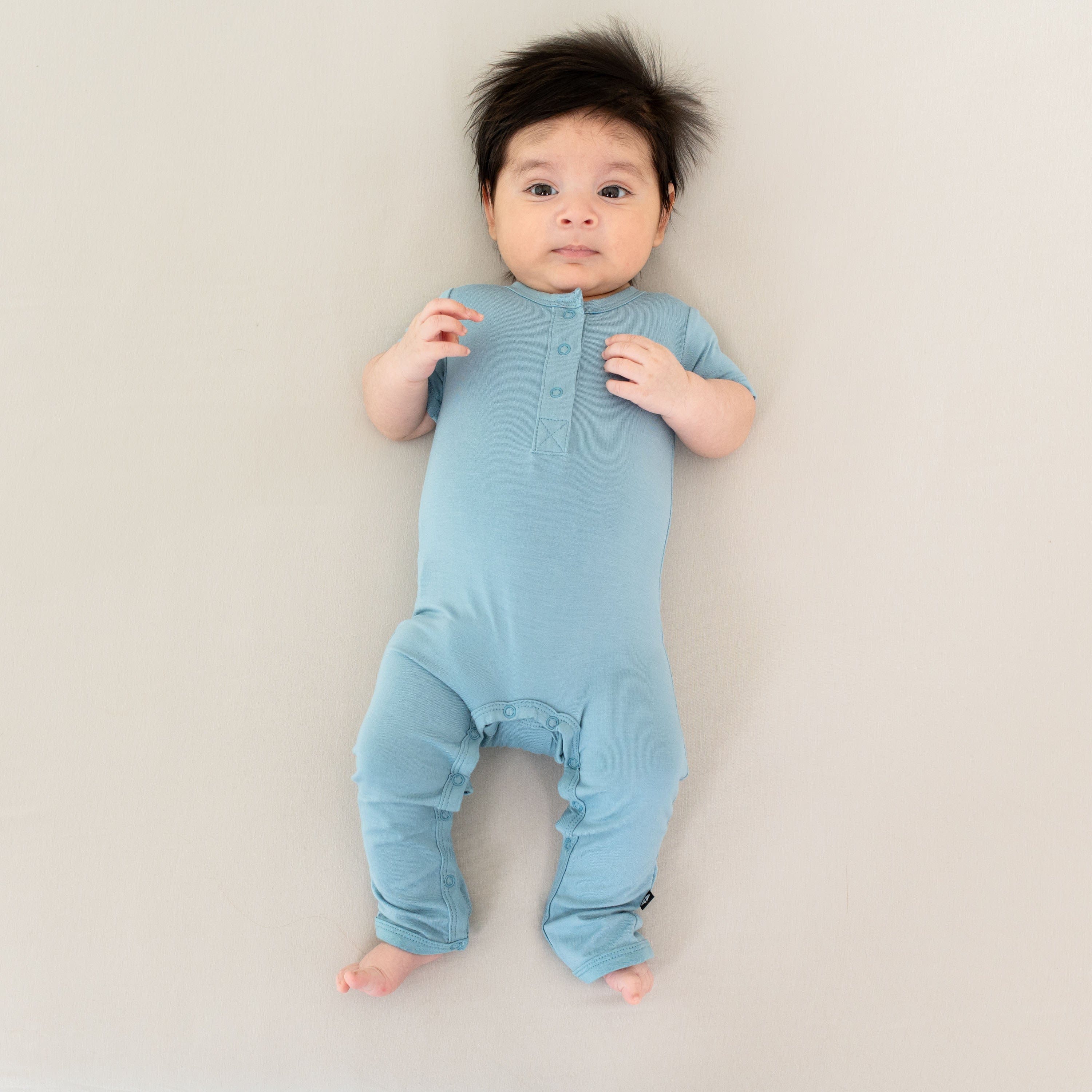 Infant wearing Kyte Baby Short Sleeve Romper in Dusty Blue
