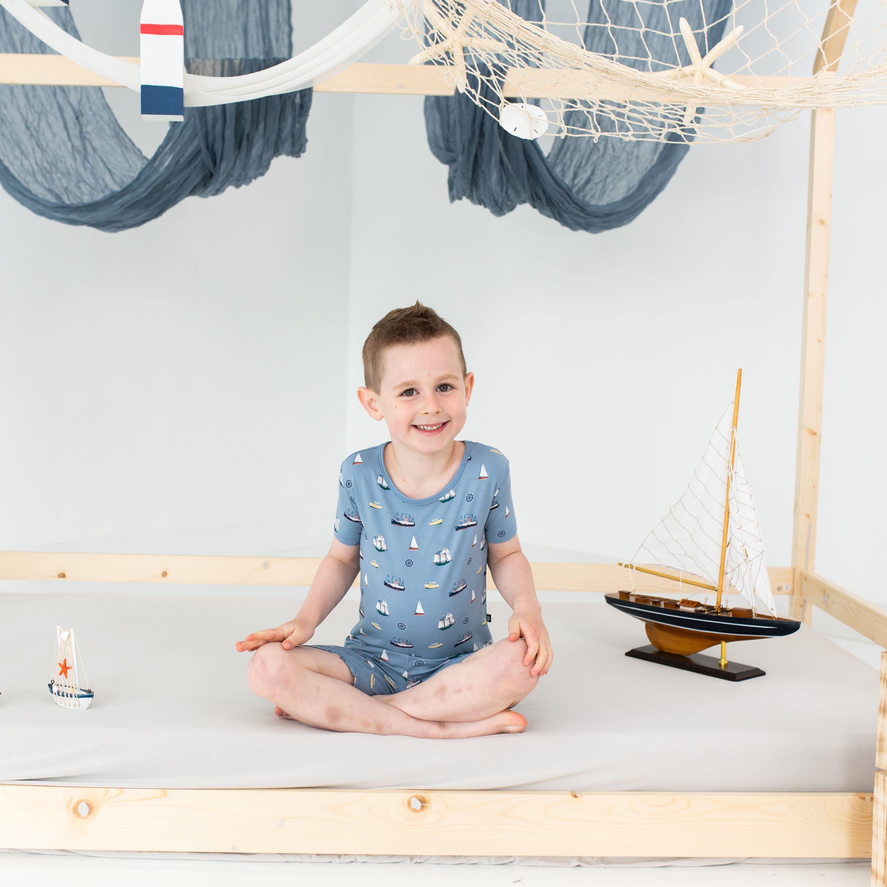 Child wearing Kyte Baby Short Sleeve Pajamas in Vintage Boats