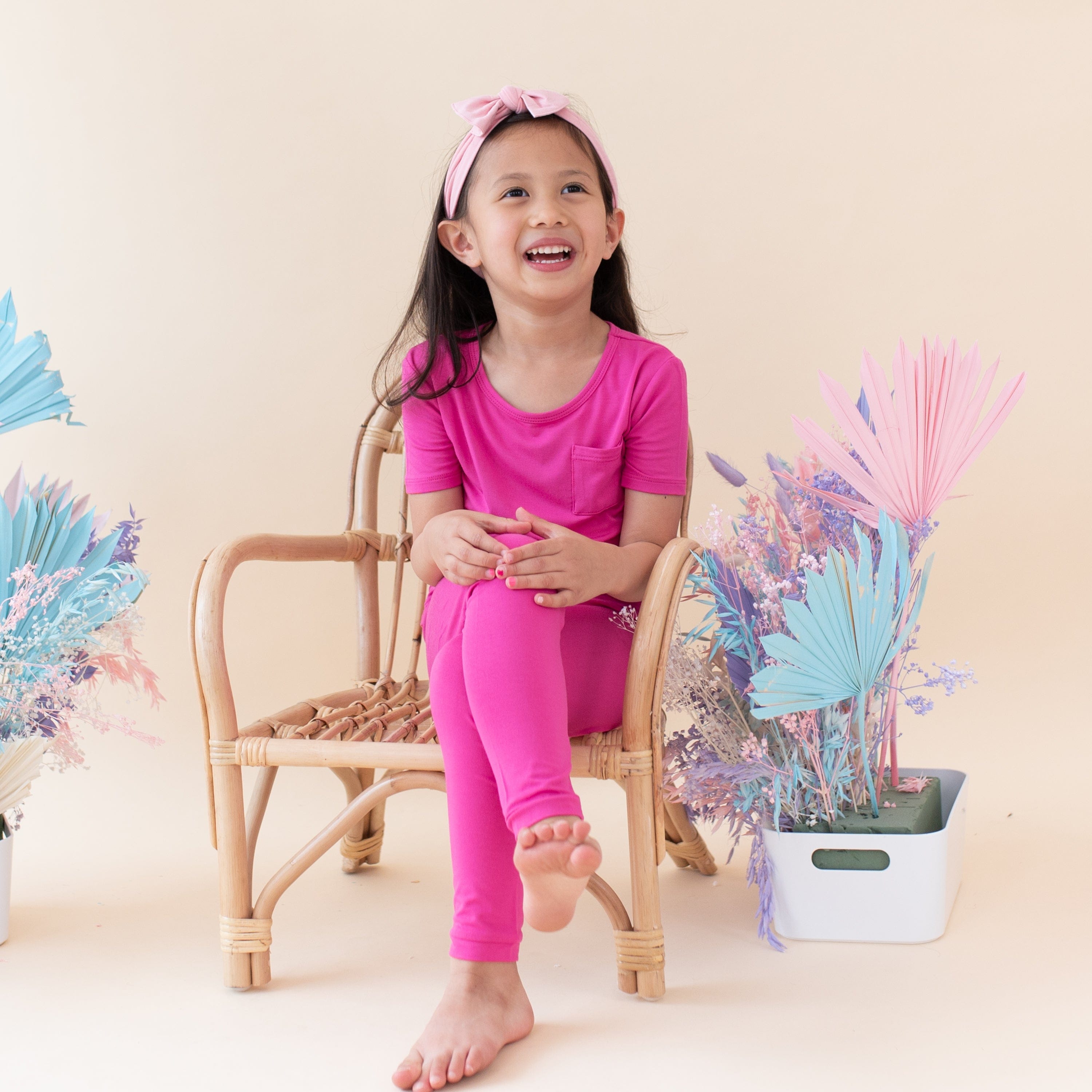 Girl wearing Kyte Baby Short Sleeve bamboo Pajamas with pants in Raspberry