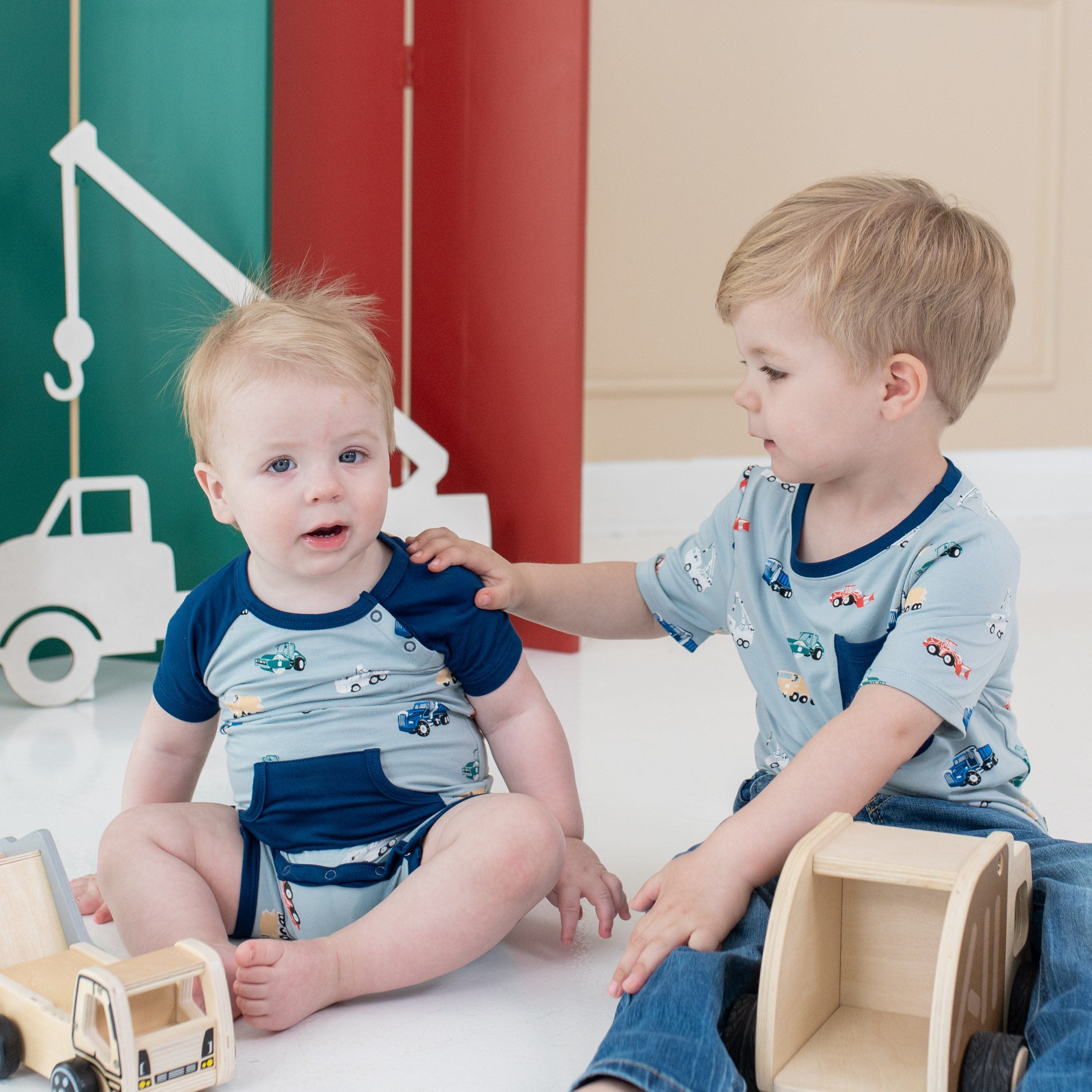 Siblings playing in Kyte Baby matching outfits in Construction