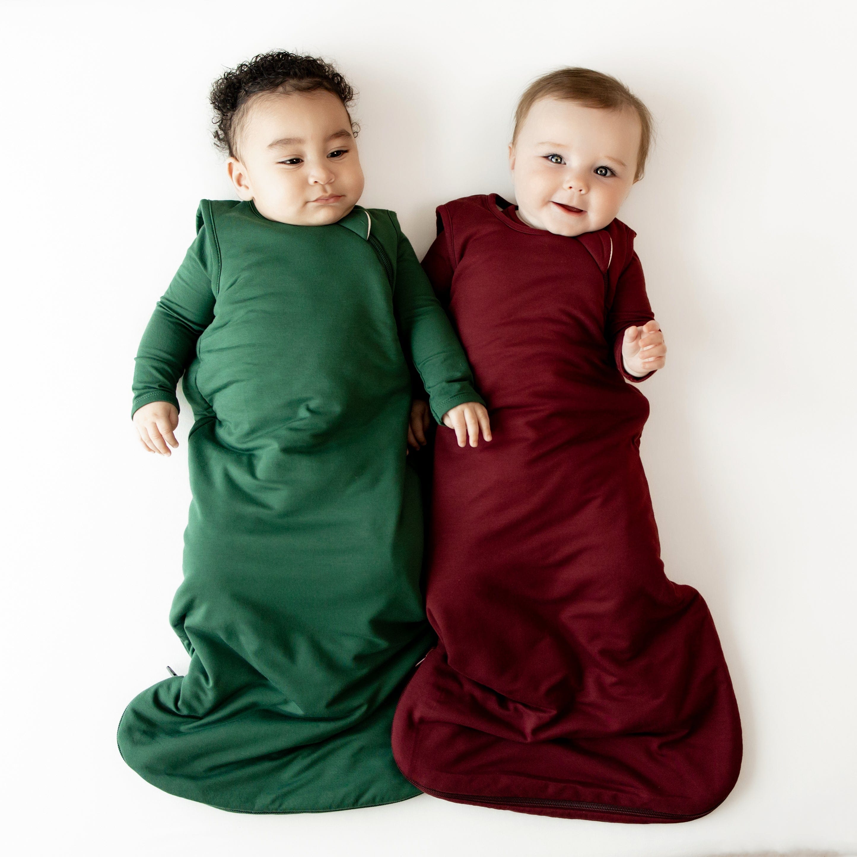 Babies wearing TOG 1.0 Christmas Sleep Bags in Evergreen and Burgundy