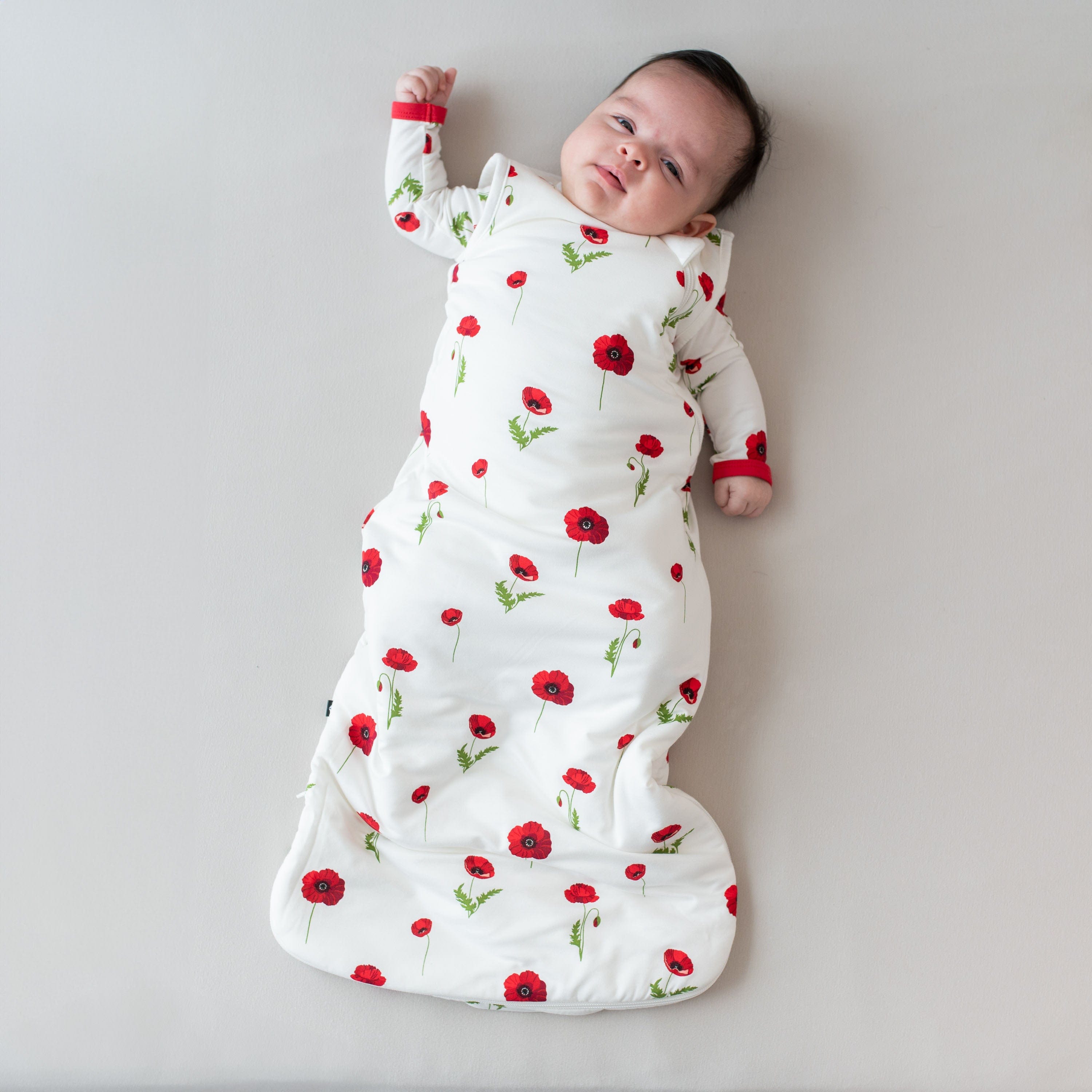Infant wearing Kyte Baby Sleep Bag in Cloud Poppies 1.0
