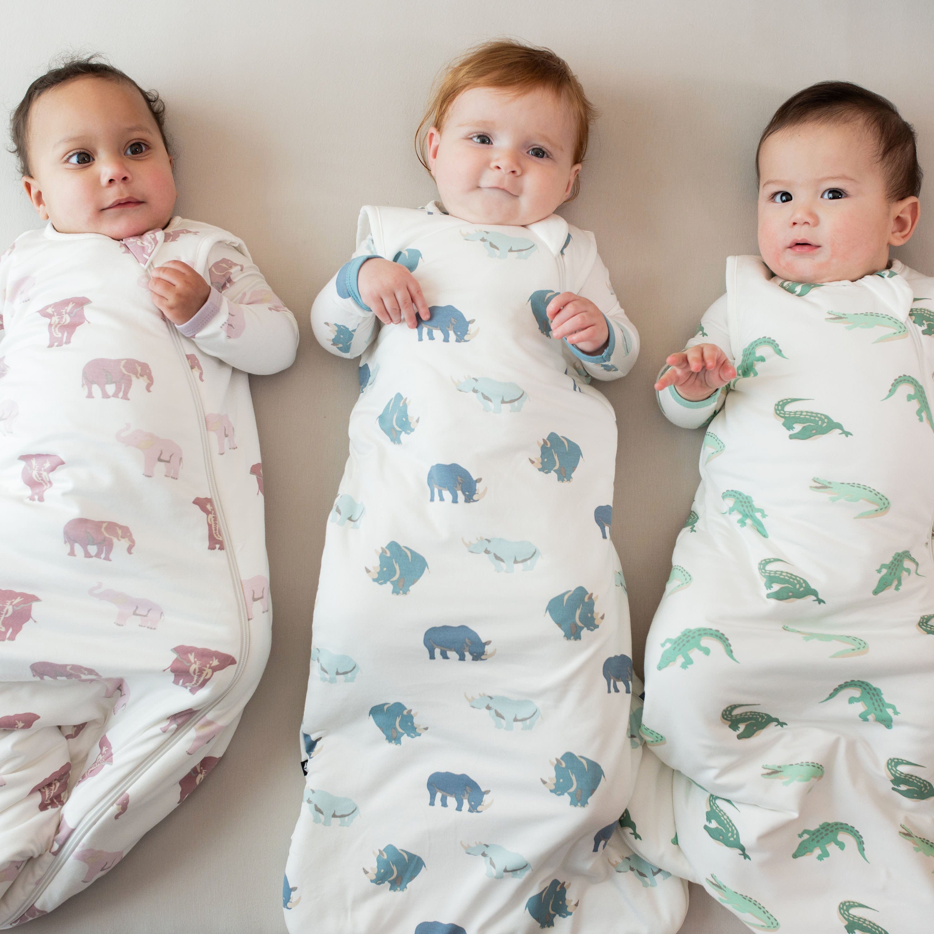 Babies wearing Kyte Baby sleep bags TOG 1.0 in Crocodile pattern
