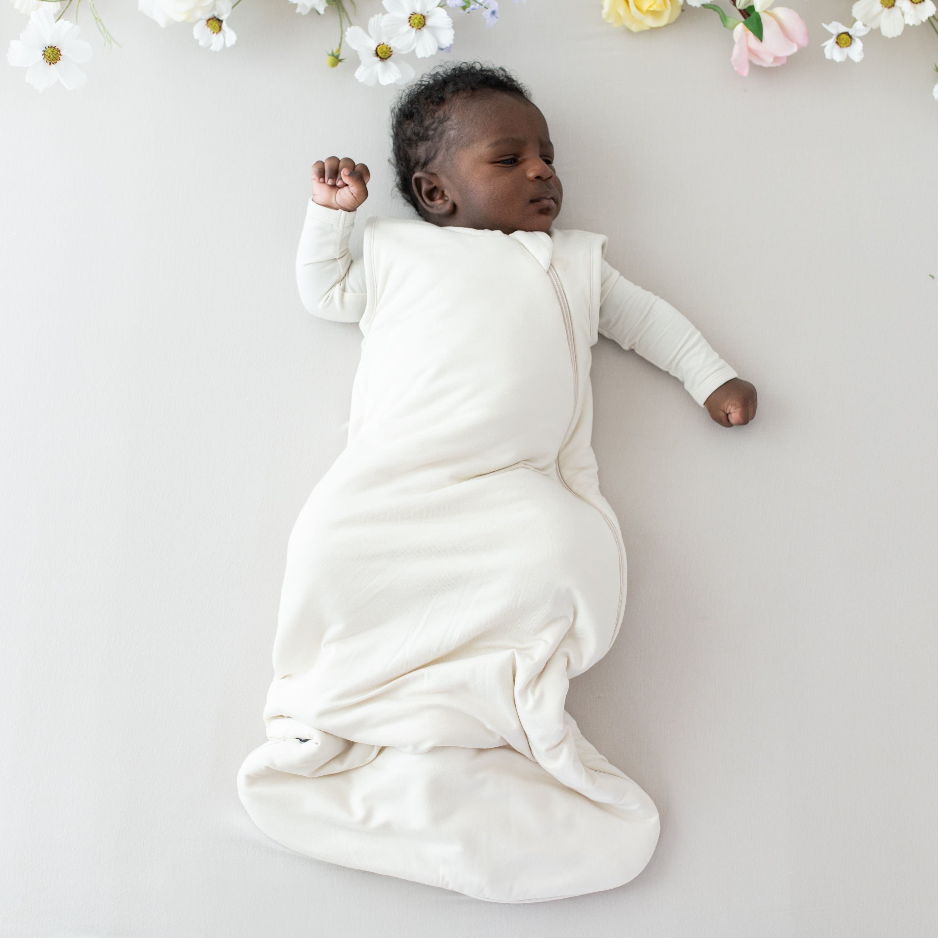 Infant wearing Kyte Baby Sleep Bag in Ecru 1.0