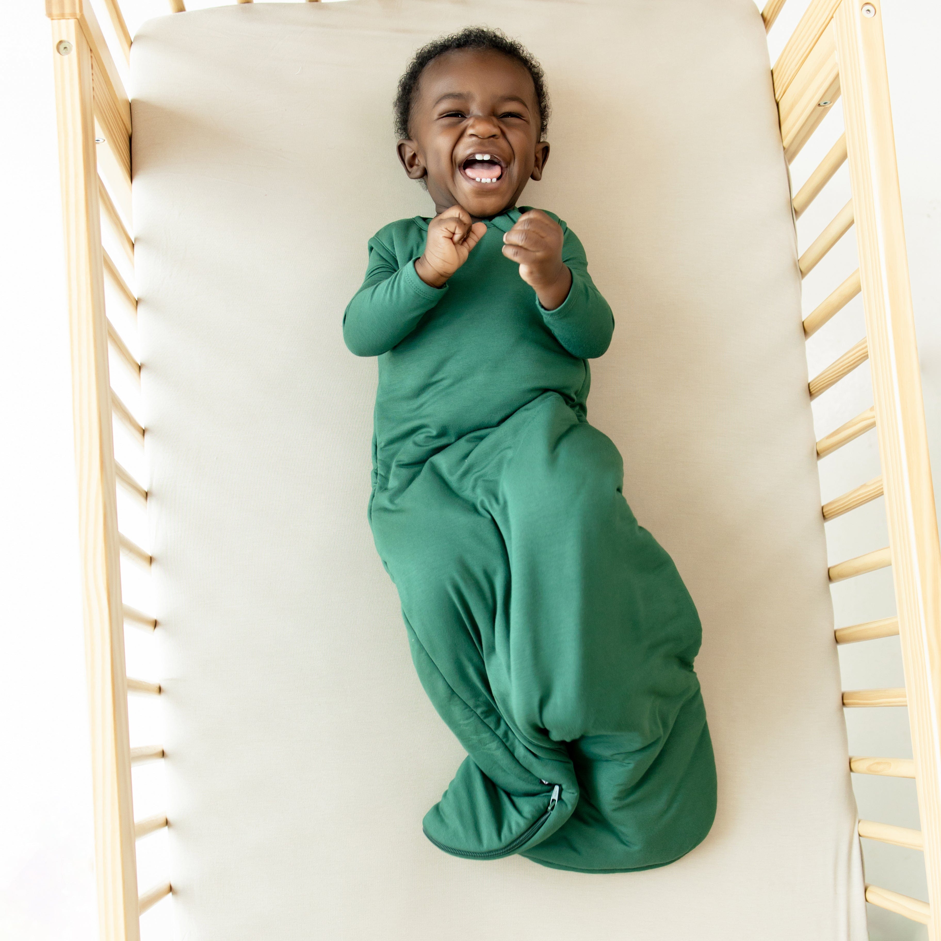 Infant wearing Kyte Baby Sleep Bag in Evergreen 1.0