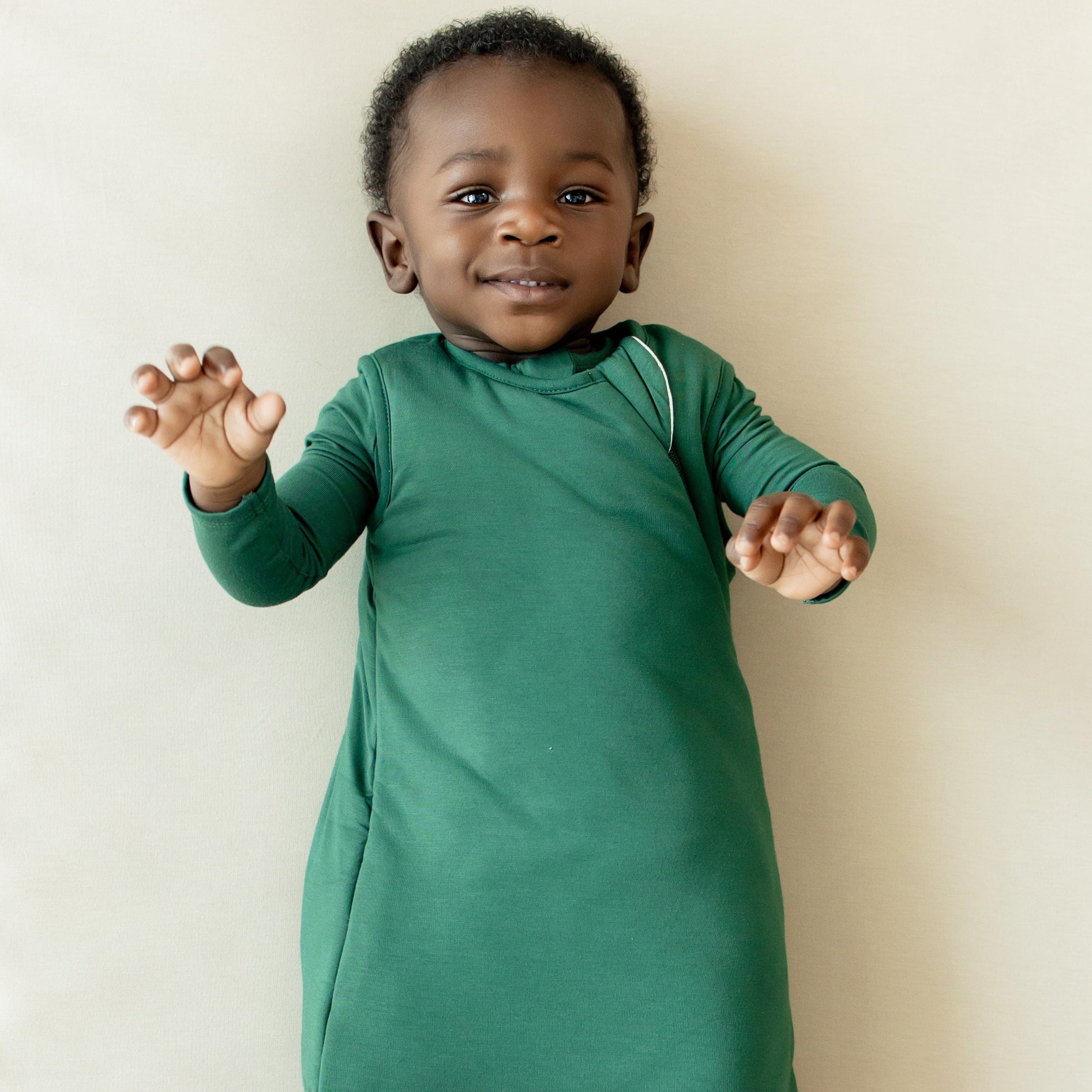 Infant wearing Kyte Baby TOG 1.0 bamboo Sleep Bag in Evergreen