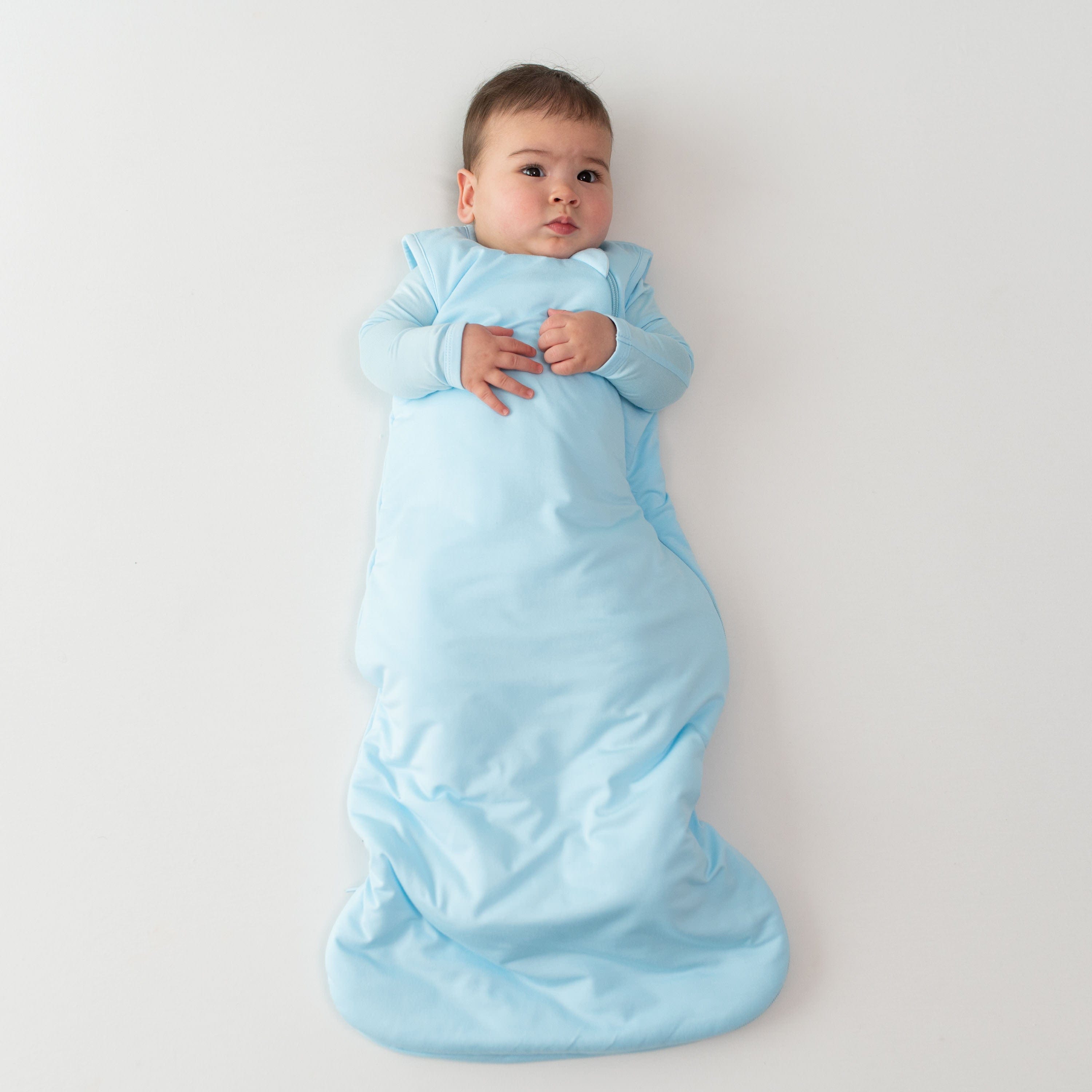 Infant wearing Kyte Baby Sleep Bag in Powder 1.0