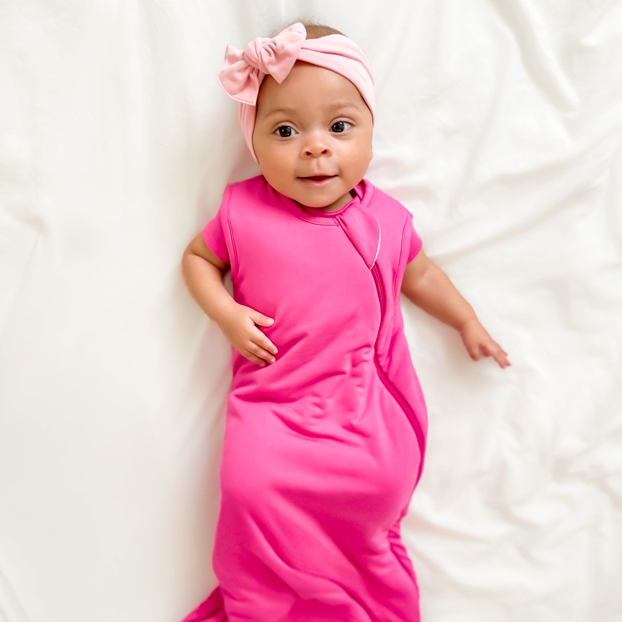 Infant wearing Kyte Baby bamboo wearable blanket Sleep Bag in Raspberry 1.0